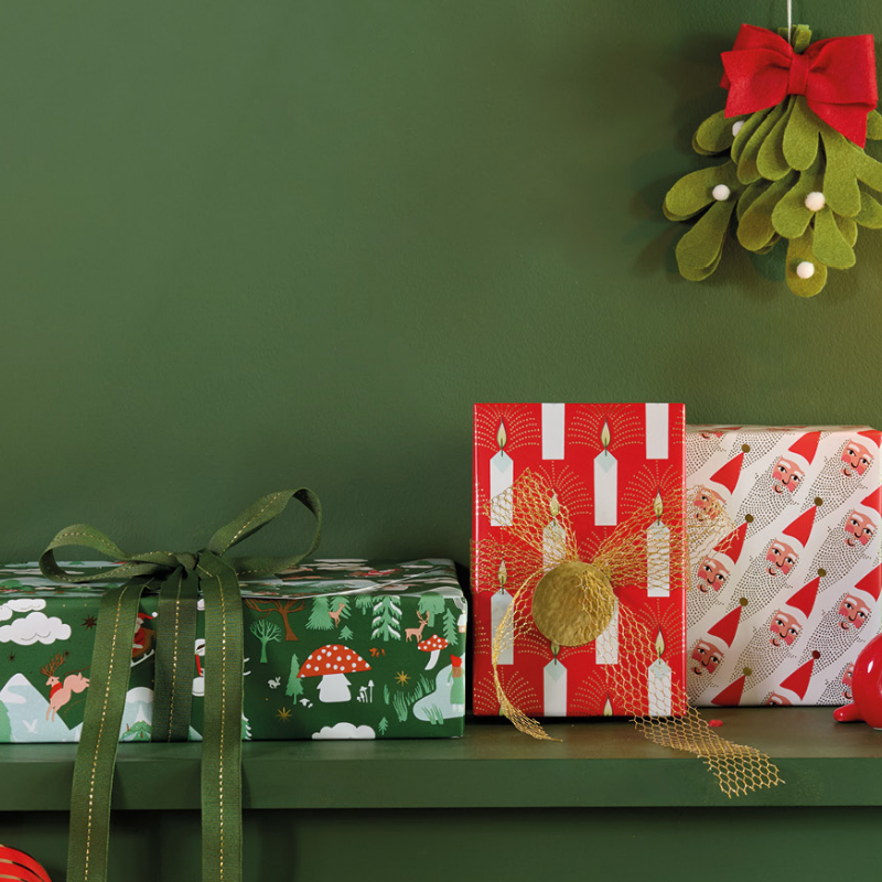 Weihnachtlich verpackte Geschenke mit Mistelzweig-Dekoration.