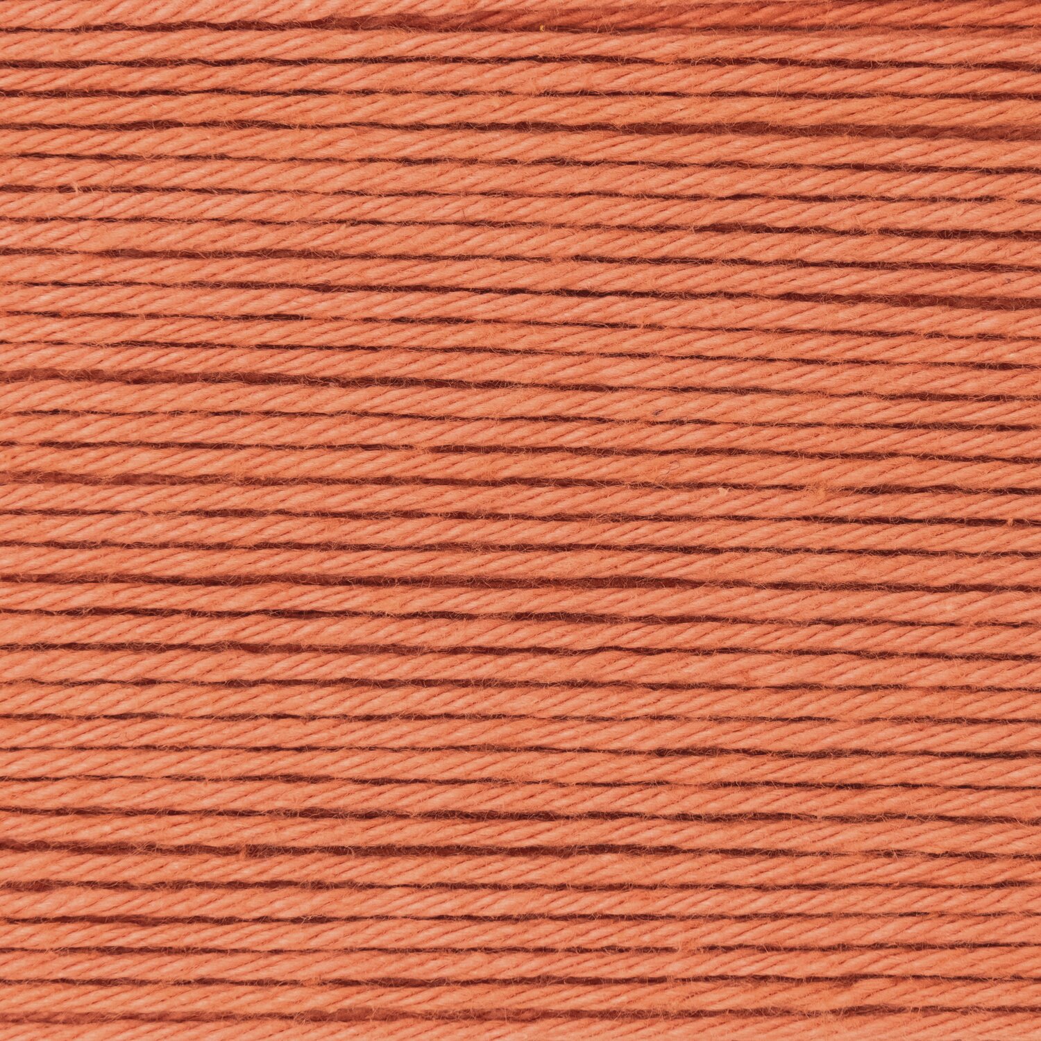 Creative Ricorumi dk zeigt glattes Baumwollgarn von Rico Design in warmem Papaya-Ton, dicht aufgewickelt als 25g-Knäuel für feine Häkel- und Strickprojekte.