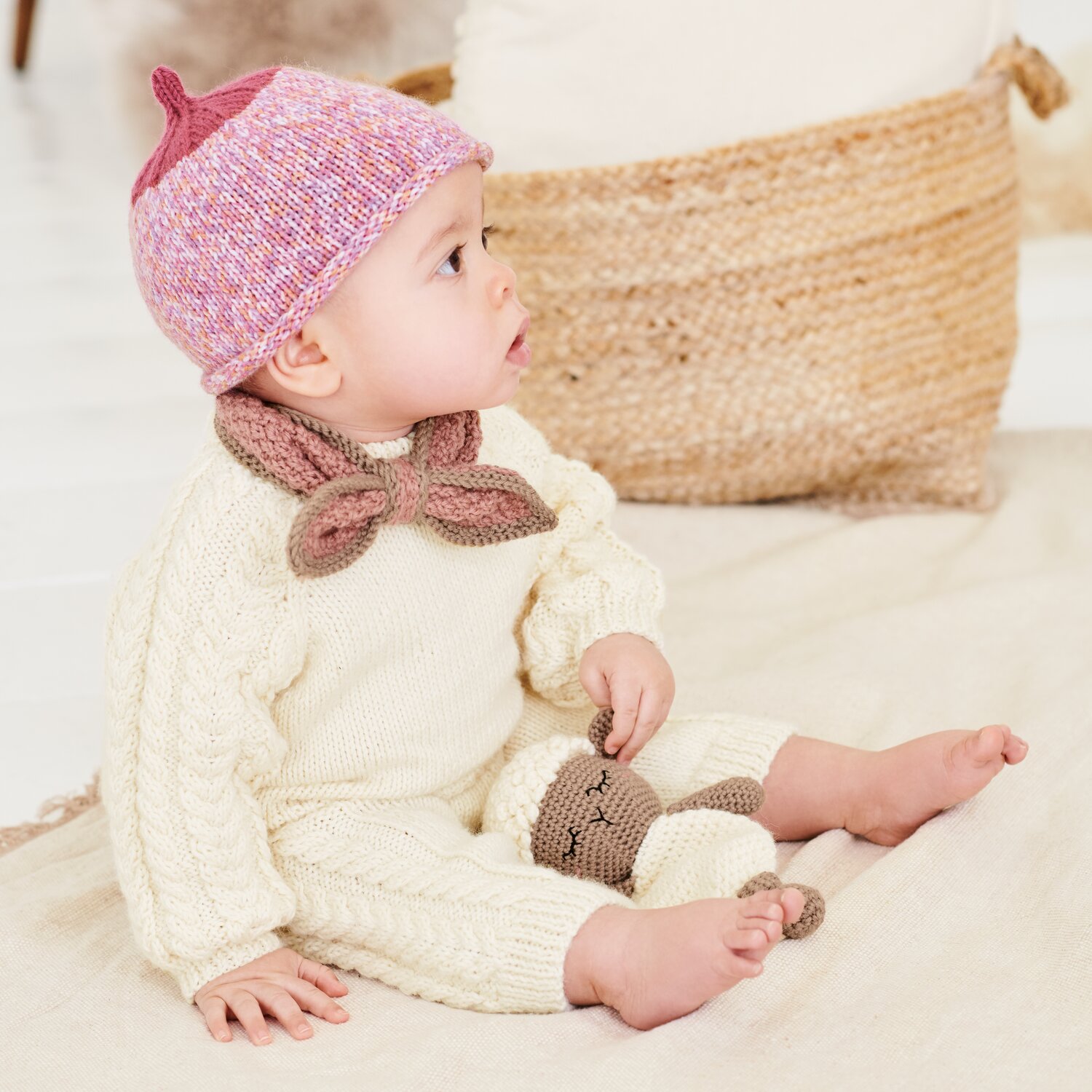 Strickset Mütze Modell 03a aus Baby 044, Strickset Pullover Modell 01 aus Baby 044 und Strickset Hose Modell 02 aus Baby 044 an sitzendem Baby mit Kuscheltier