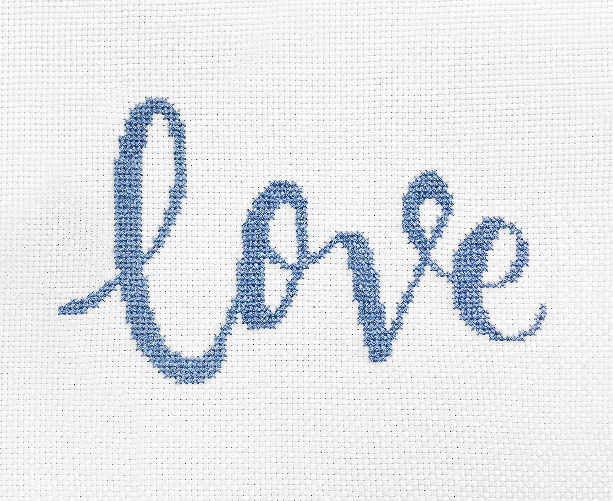 Das Wort "Love" ist im gezählten Kreuzstich-Muster auf Stramin gestickt