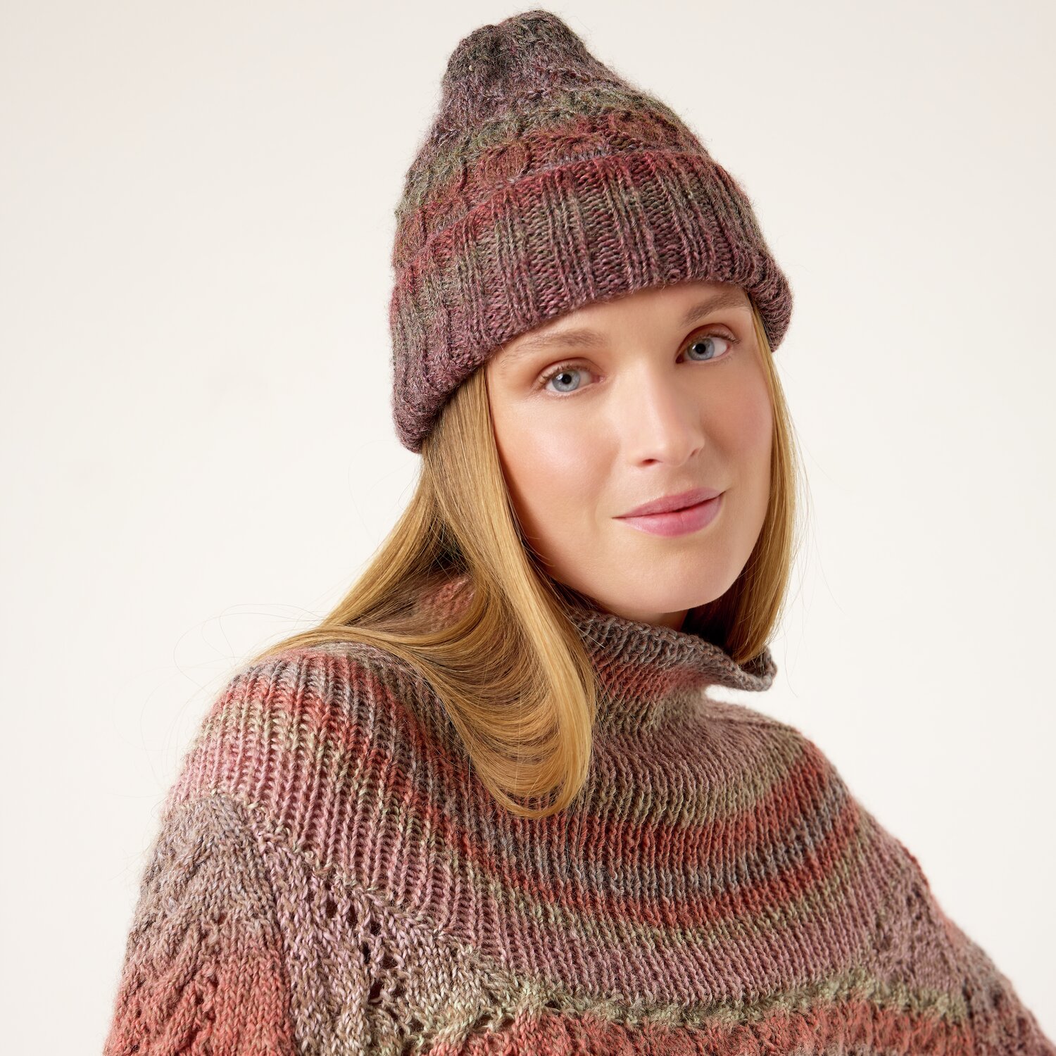 Strickset Mütze Modell 14 aus Die Neue Masche No. 13 von idee. Creativmarkt Strickset Mütze Modell 14 aus Die Neue Masche No. 13: Frau trägt gestrickte Mütze und Pullover in warmen Erdtönen.