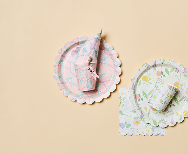 Zwei Pappbecher und Pappteller mit Servietten in jeweils passenden floralen Motiven. Flatlay von Produkten der Kollektion The Sky Is The Limit.