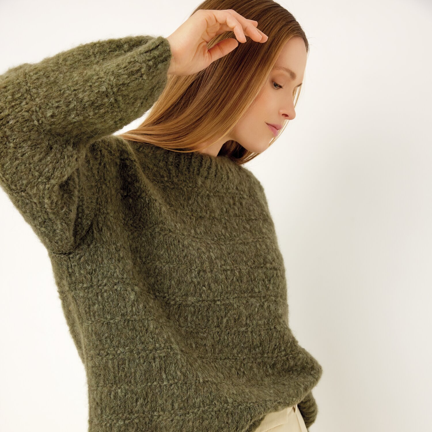 Strickset Pullover Modell 21 aus Die Neue Masche No. 13 von idee. Creativmarkt Strickset Pullover Modell 21 aus Die Neue Masche No. 13: Frau trägt olivgrünen Pullover.