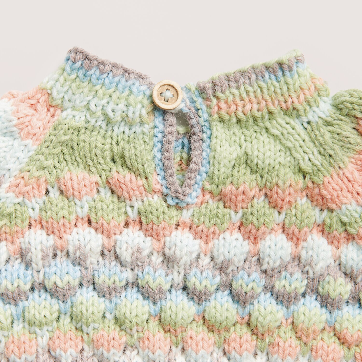 Rico Baby 042 Pullover aus Rico Baby Dream dk A Luxury Touch, gestrickt in sanften Pastelltönen mit Knopfverschluss.