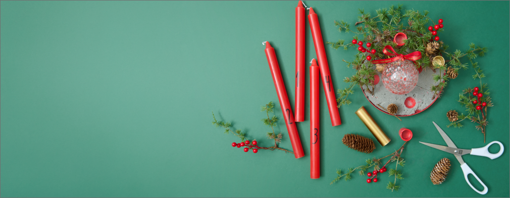 Kreativ gestalteter Adventskranz mit Kerzen, Beeren und Naturmaterialien.