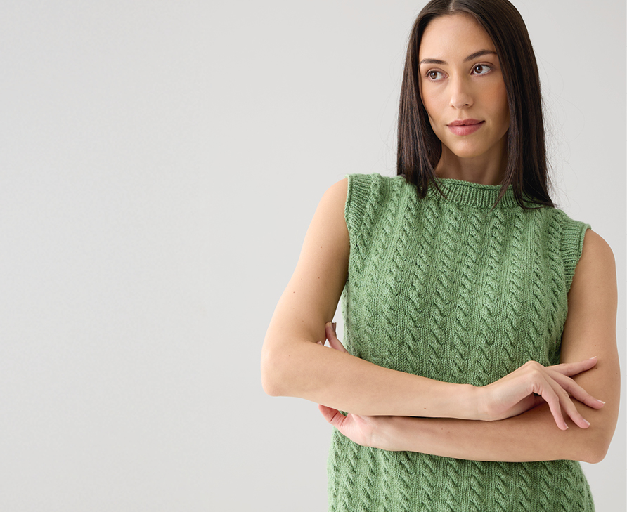 Eine Frau trägt ein gestricktes Top in grün