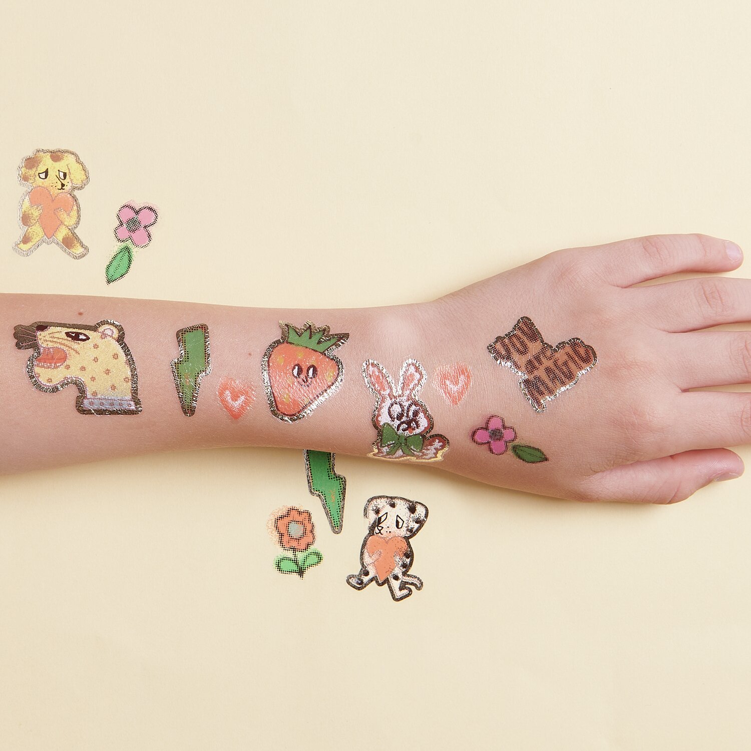 Tattoos Früchte und Tiere: Bunte temporäre Tattoos mit Tier- und Fruchtmotiven auf einem Arm.