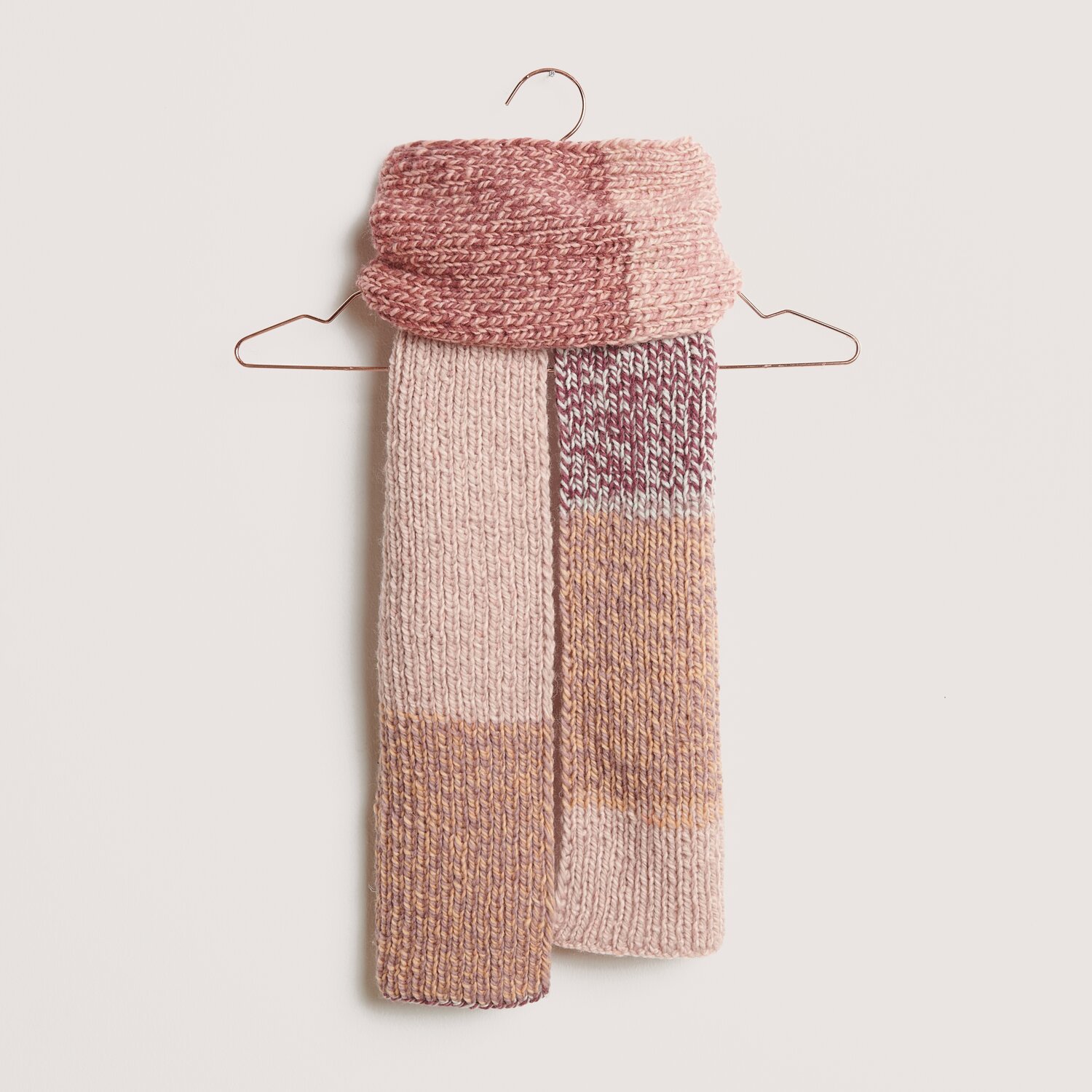 Die Neue Masche No. 14 Winter von idee. Creativmarkt Peaches: Strickschal in Rosa- und Beigetönen, aufgehängt an einem Kleiderbügel. Creative Chic-Unique.