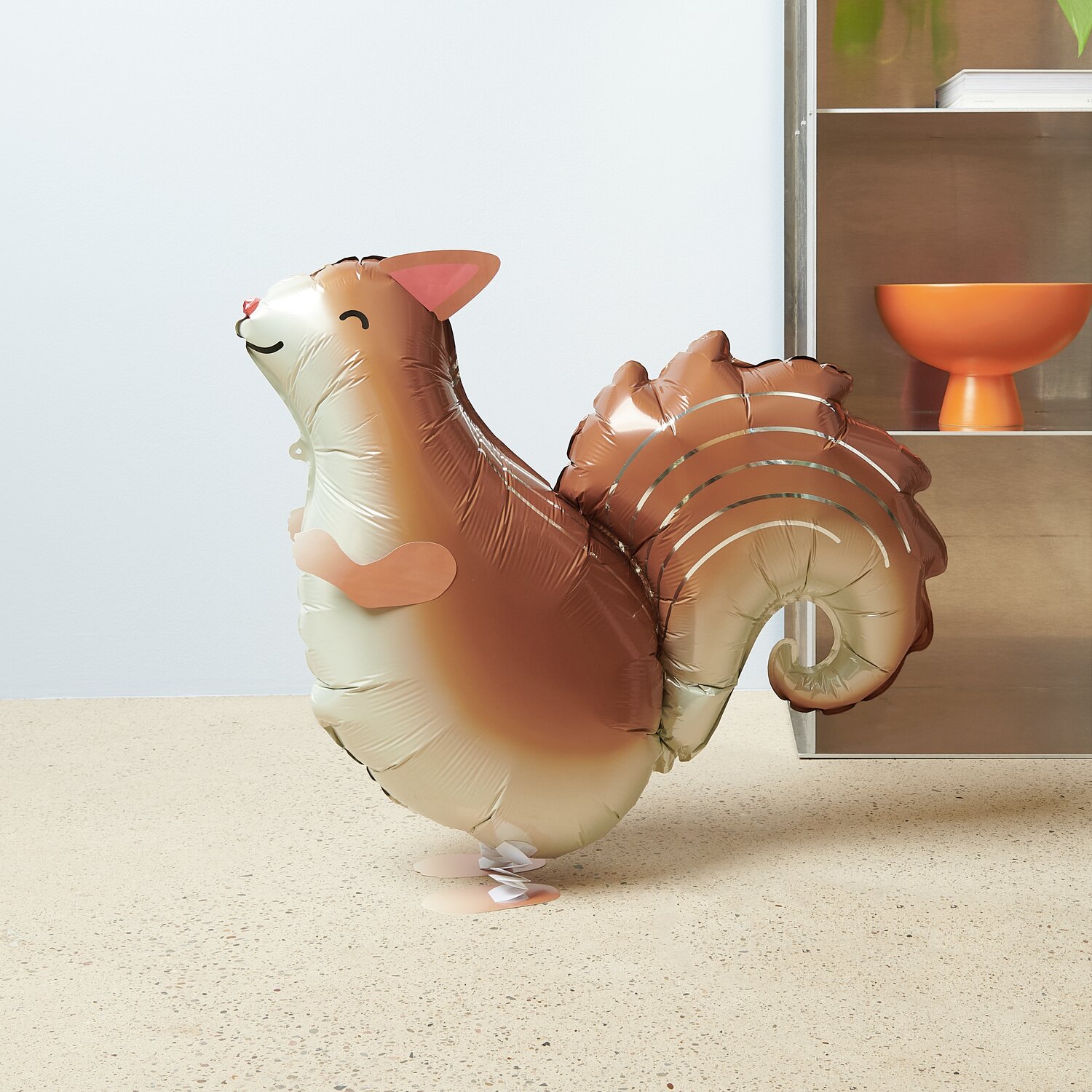 Folienballon Airwalker Eichhörnchen in Braun, 63x50x19cm. Der Ballon steht aufrecht auf einem hellen Boden.