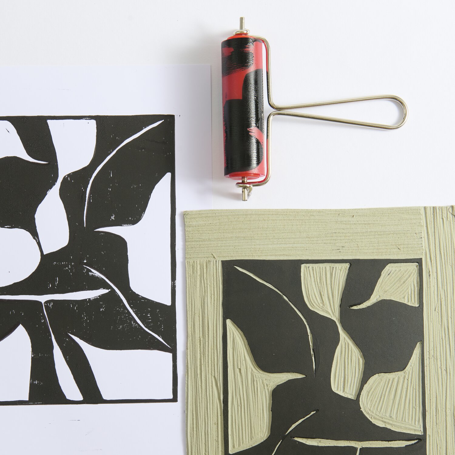 Linolwalze von Rico Design, Ø3cm, in Rot-Schwarz. Abgebildet mit Druck und Linolschnitt auf weißem Hintergrund.