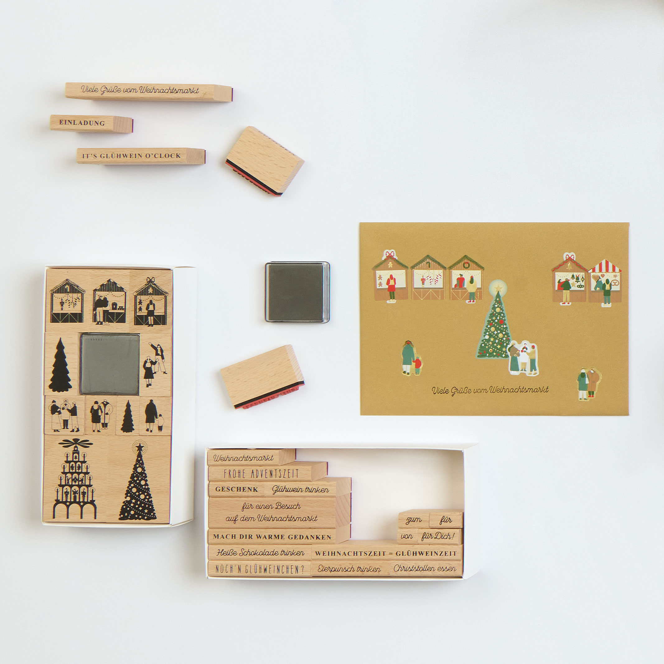 Zwei weihnachtliche Stempelsets und eine Karte mit weihnachtlichen Motiven und Spruch verziert. Flatlay von Produkten.