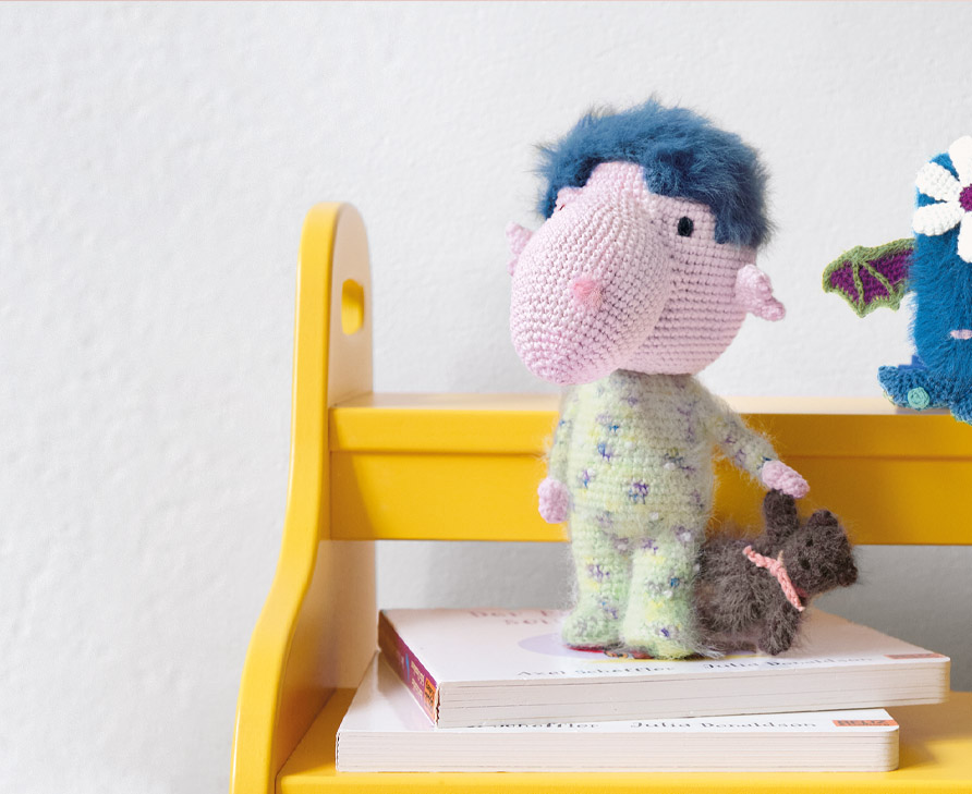 2 gehäkelte Ricorumi Monster stehen auf einer Bank