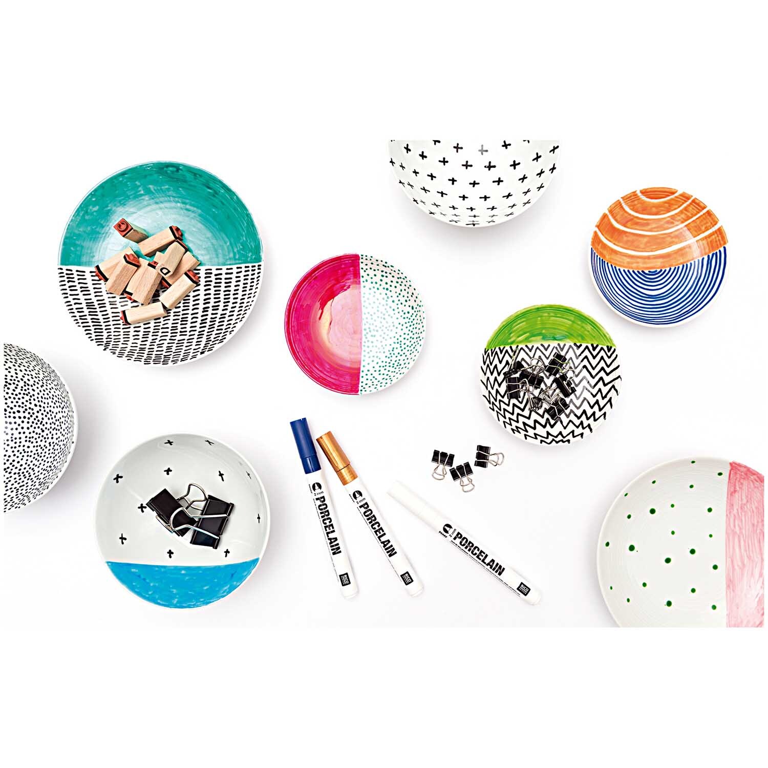 Porzellanmarker 2mm von Rico Design in Schwarz, umgeben von kreativ bemalten Schalen und Tellern.