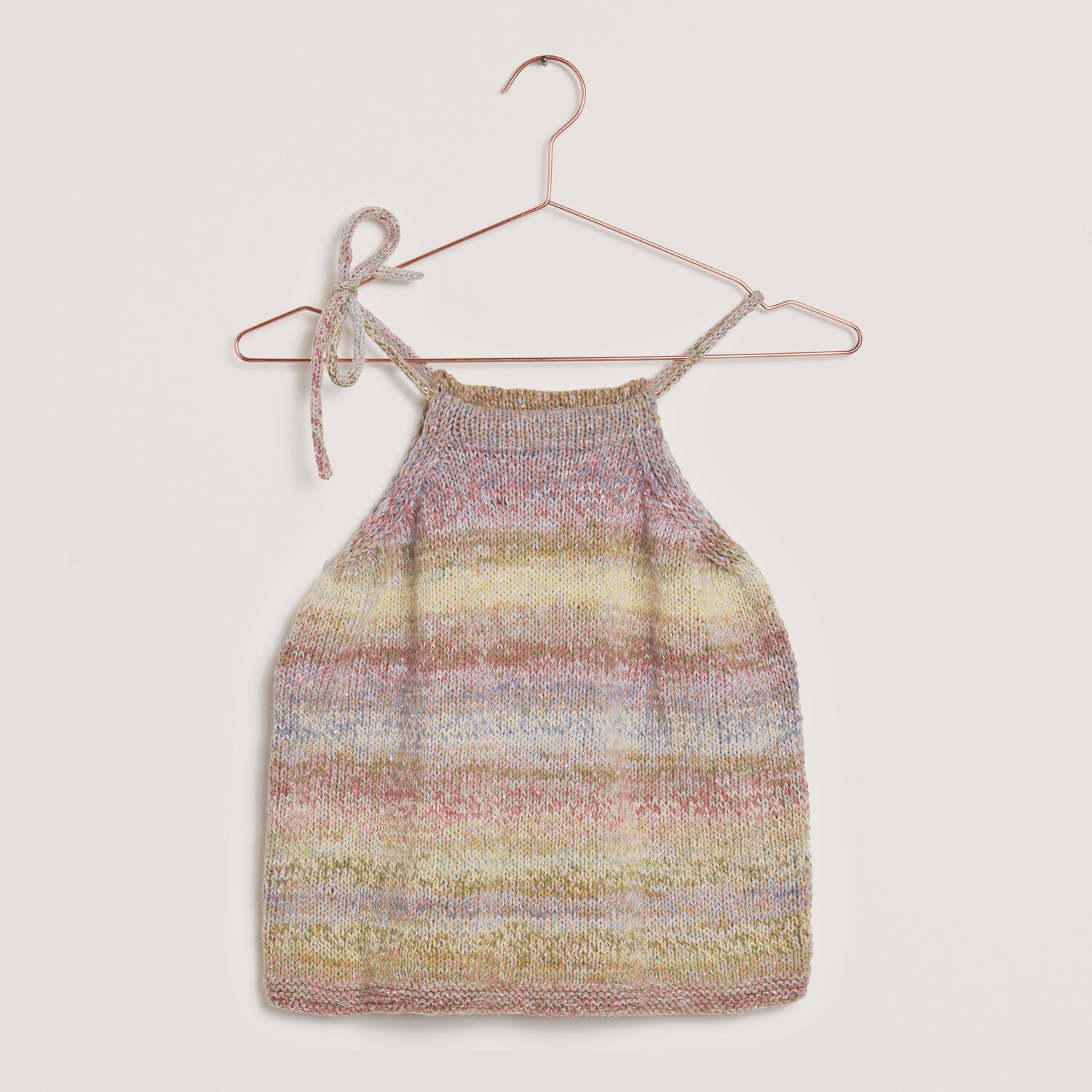 Creative Make It Blümchen: Stricktop in sanften Erdtönen, auf einem roségoldenen Bügel präsentiert.