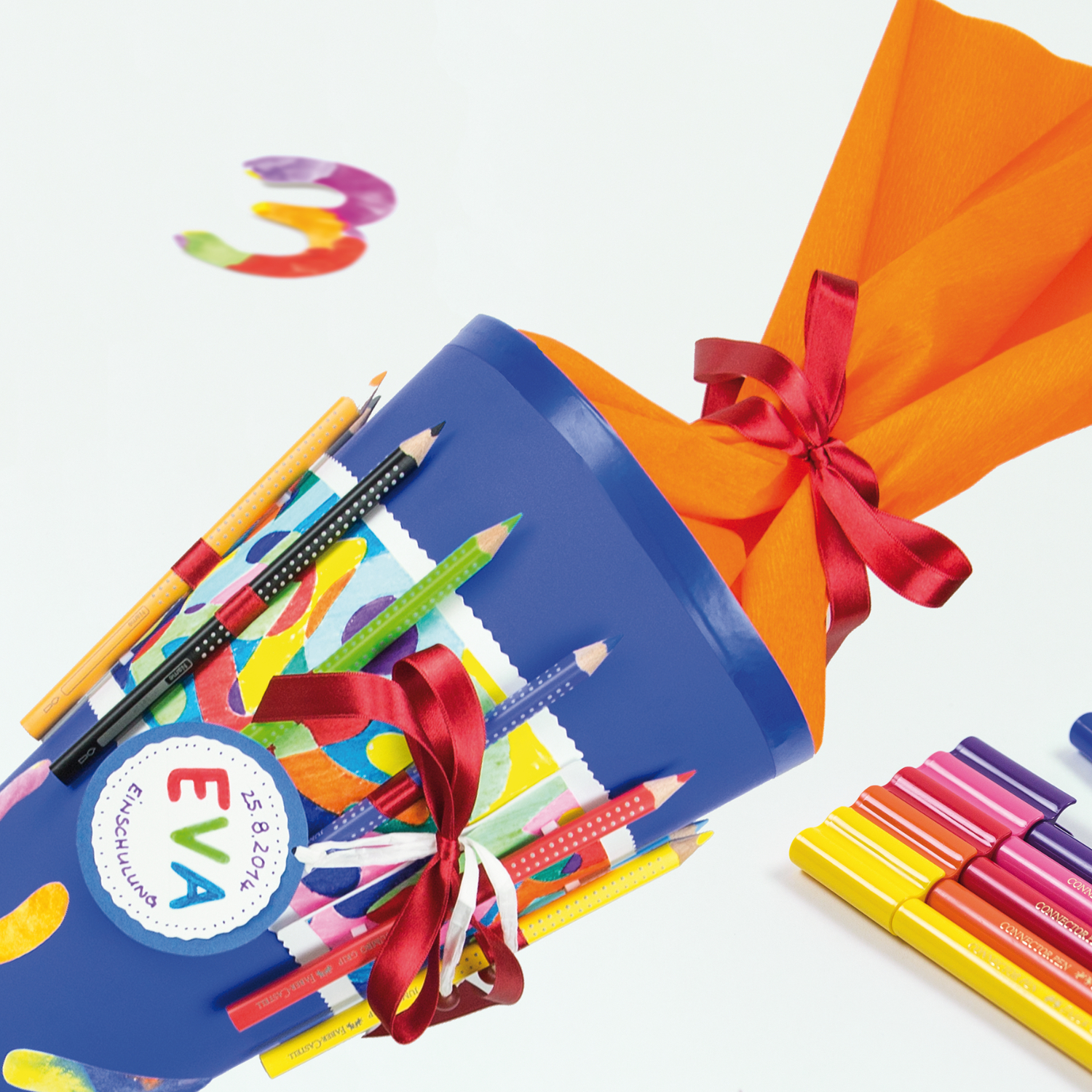 Jumbo Grip Farbstift in Kobalttürkis von Faber Castell, dekoriert auf einer blauen Schultüte mit bunten Bändern und Stiften.