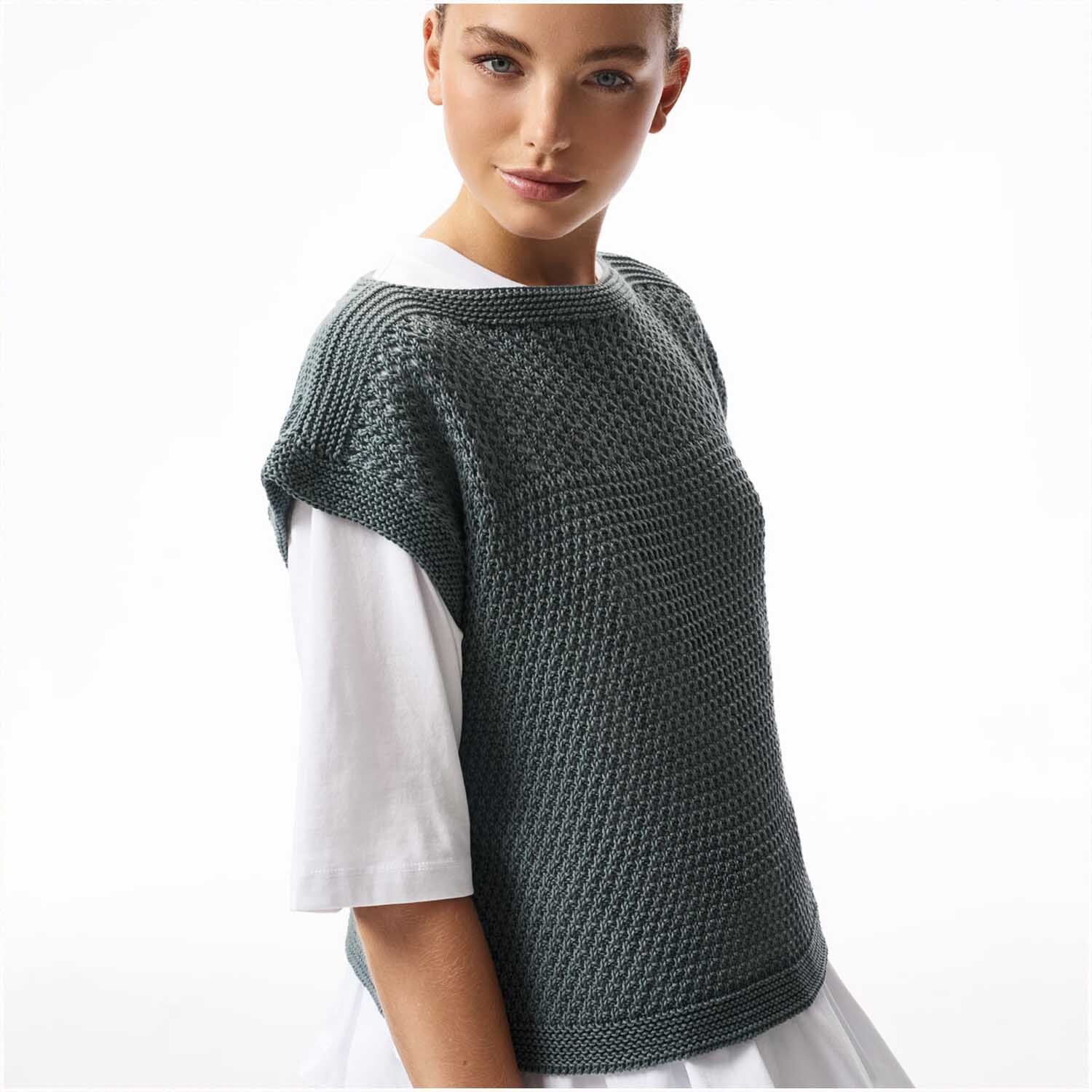 Essentials Cotton Silk Cashmere dk: Frau trägt gestricktes Oberteil in Grau von Rico Design über weißem Shirt.