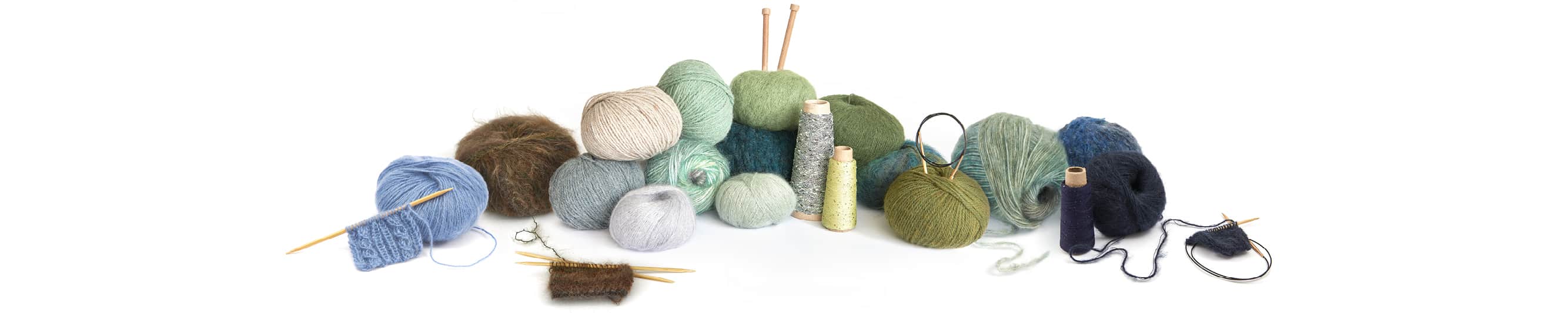 Wollknäuel in verschiedenen Farben aneinandergereiht und übereinandergestapelt