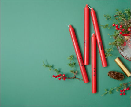 Kreativ gestalteter Adventskranz mit Kerzen, Beeren und Naturmaterialien.