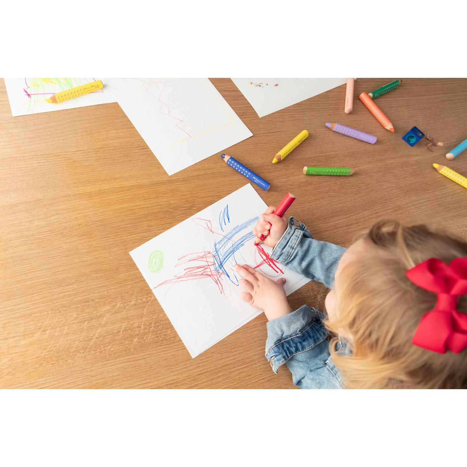 Buntstift Grippy Set: Kind malt mit bunten Stiften auf Papier. Faber Castell, 11-teilig.