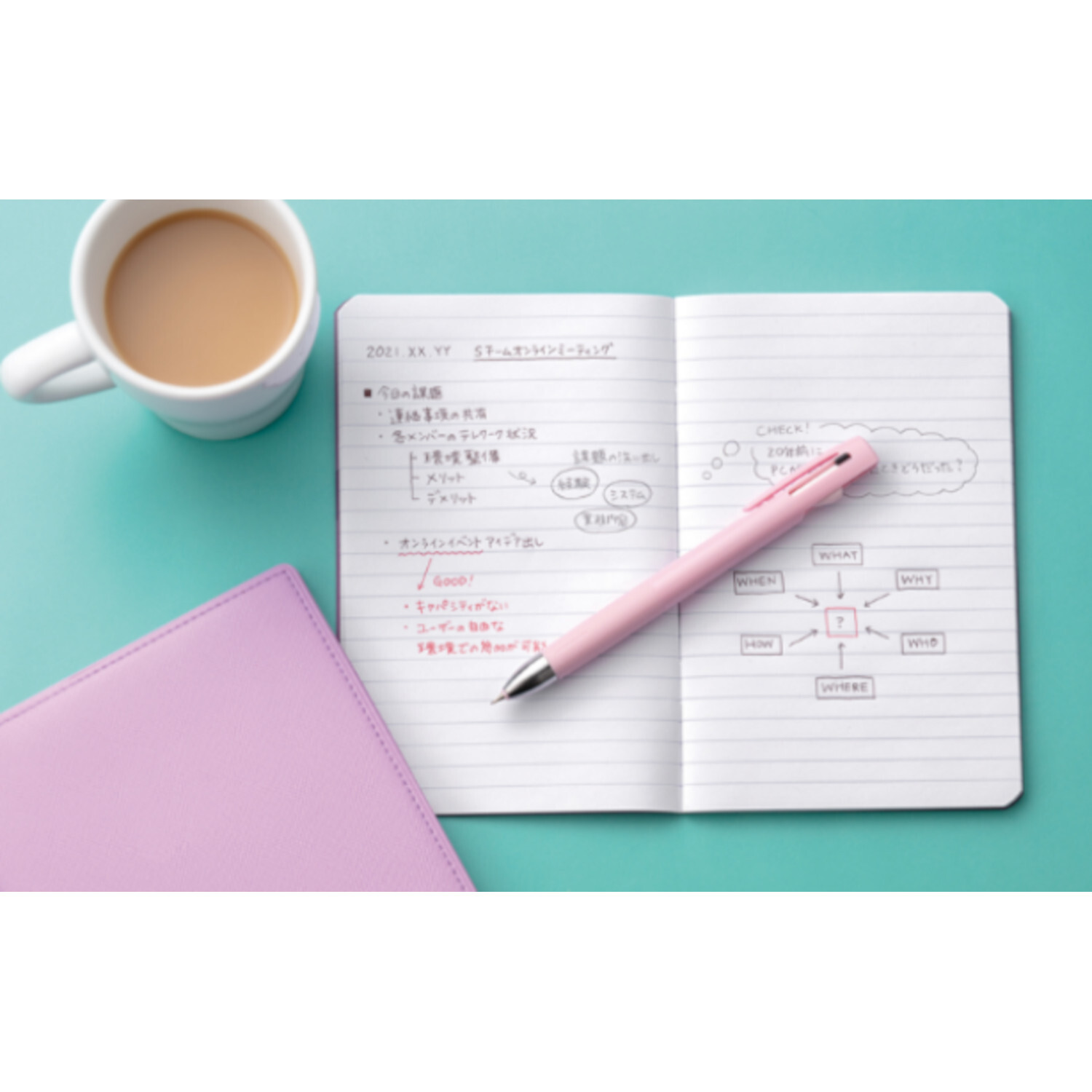 Kugelschreiber bLen 2+S auf einem Notizbuch mit rosa Einband, daneben eine Tasse Kaffee.