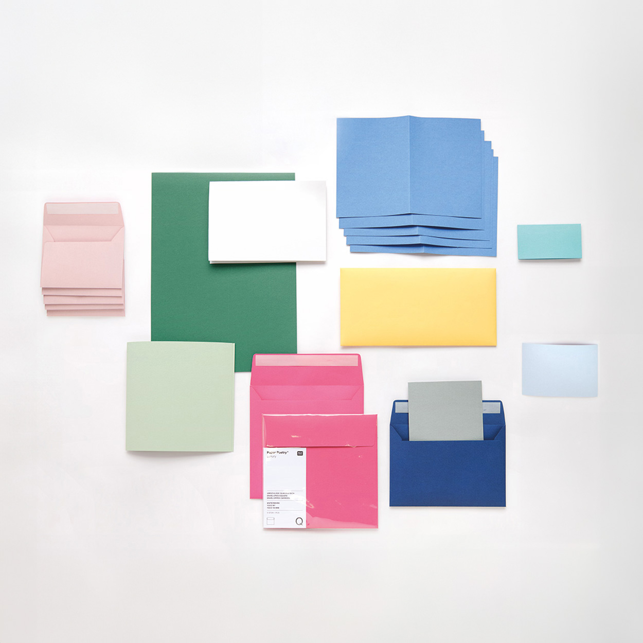 Umschläge und Karten in verschiedenen Farben und Größen teilweise übereinandergelegt. Flatlay von Produkten.