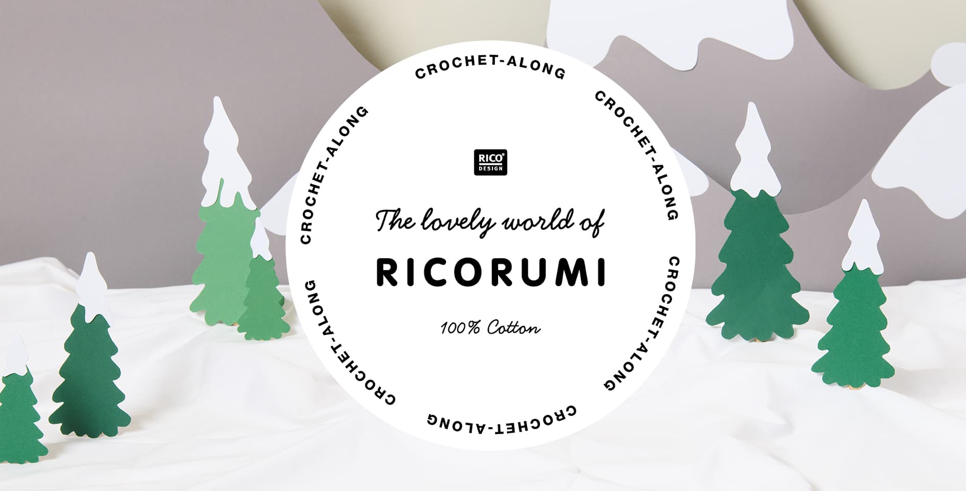 Eine aus Papier gestaltete Schneelandschaft. Davor ein Logo von Ricorumi.