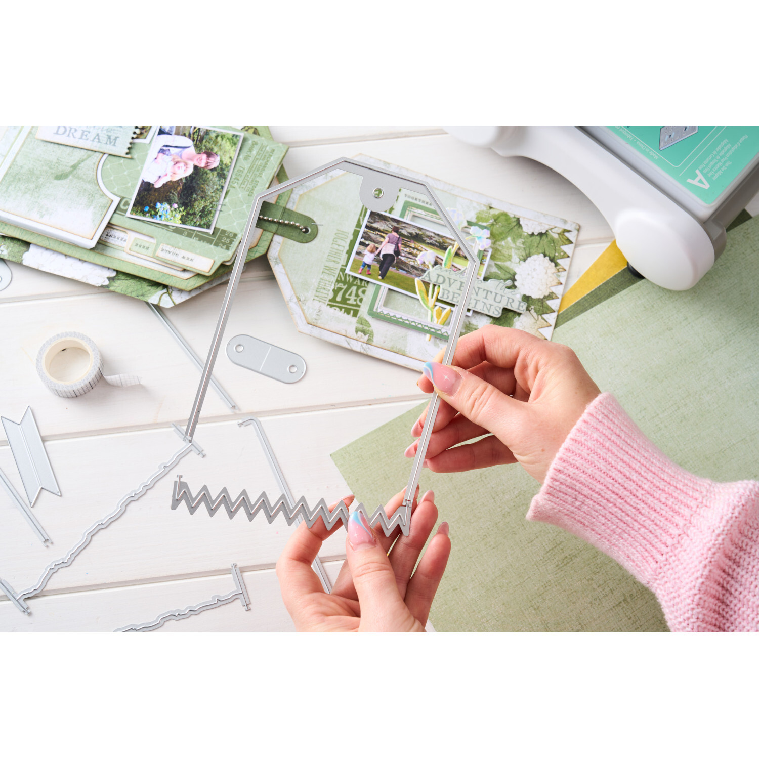 Thinlits Die Set Swap and Swap Large Tags, 17-teilig. Hände halten Stanzformen über Bastelmaterialien.