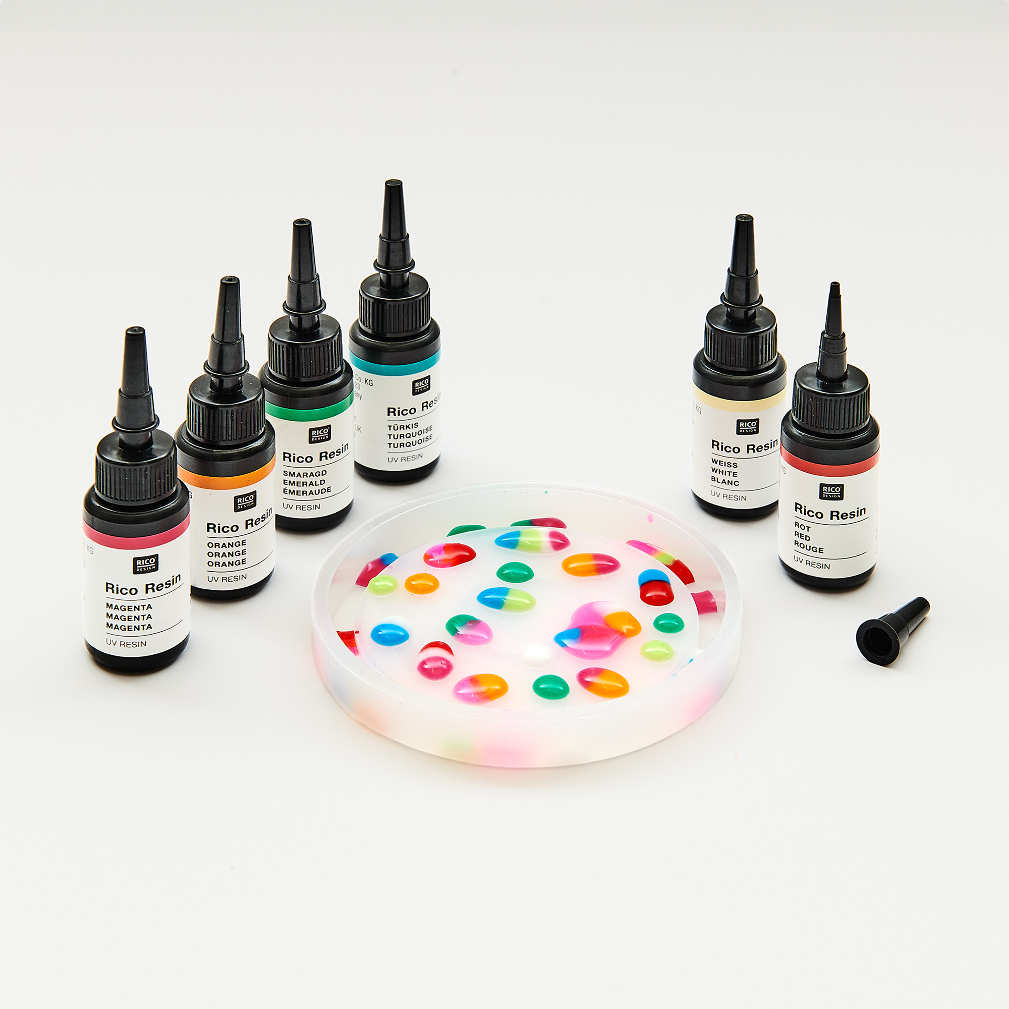 Silikonform mit bunten Tropfen befüllt und von UV-Resin-Fläschchen, in unterschiedlichen Farben, umrandet.