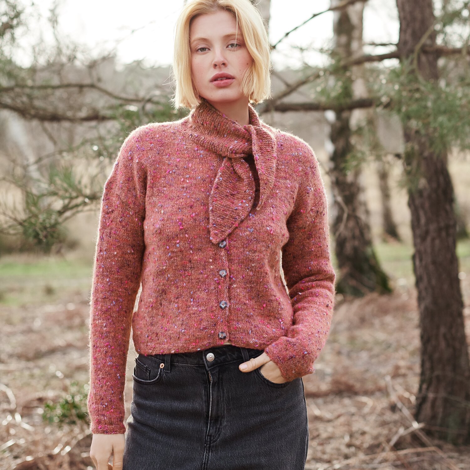 Strickset Jacke Modell 31 aus Lovewool No. 21 von Rico Design Strickset Jacke Modell 31 aus Lovewool No. 21, rosa, im Wald getragen, kombiniert mit dunkler Jeans.