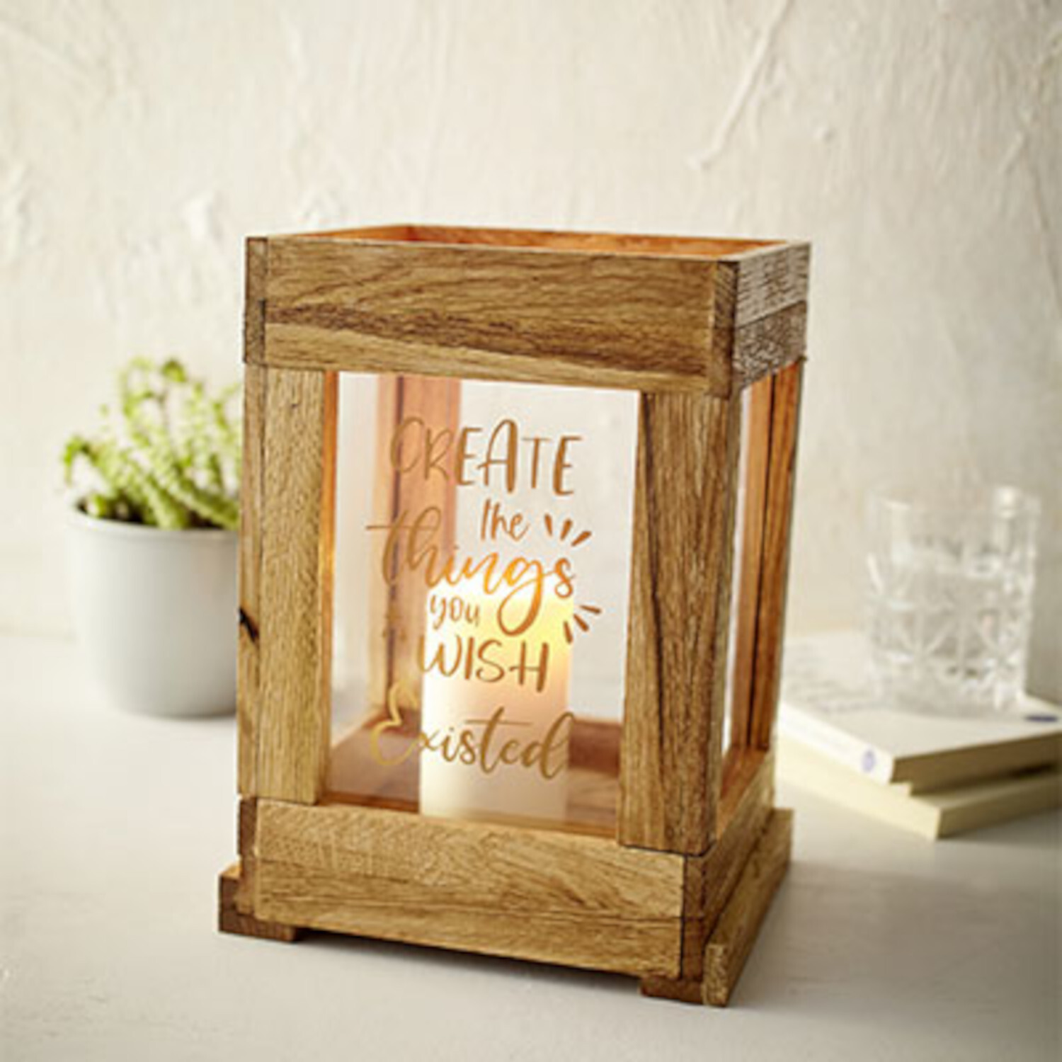 Klötzchenfieber! Holzlaterne mit Glas und inspirierendem Zitat, dekoriert auf einem Tisch.