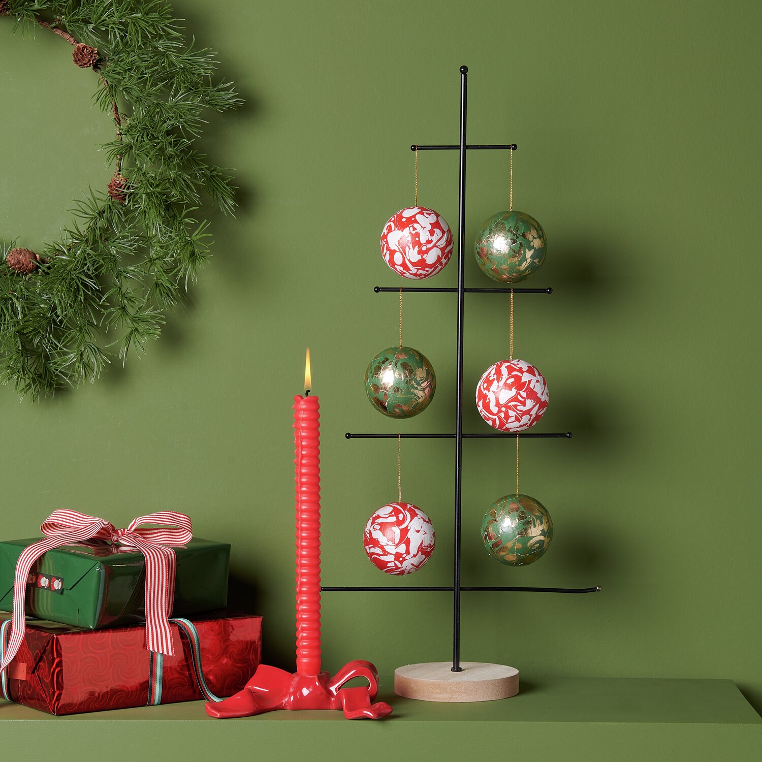 Paper Patch Weihnachtsmarkt marmoriert: Sechs marmorierte Kugeln in Grün-Gold und Rot-Weiß an modernem Baumständer, neben Geschenken und Kerze.