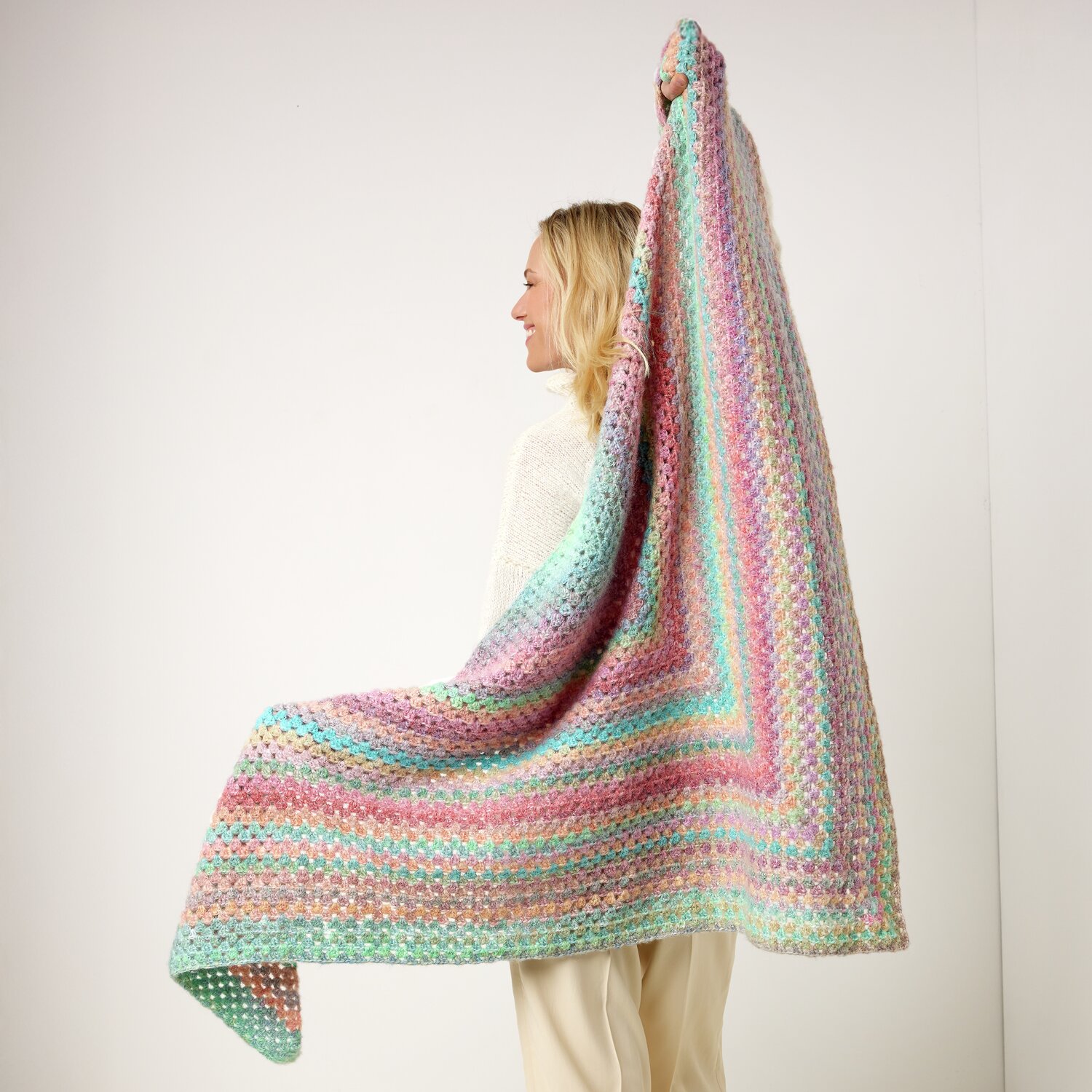 Häkelset Dreieckstuch Modell 11 aus Die Neue Masche No. 13 von idee. Creativmarkt Häkelset Dreieckstuch Modell 11: Frau hält pastellfarbenes Tuch aus Die Neue Masche No. 13.
