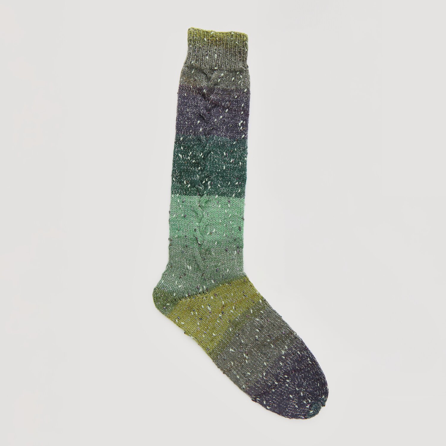 Lovewool No. 21 Herbst-Winter Sprachauswahl deutsch von Rico Design Bunte Stricksocke in verschiedenen Grüntönen, von dunkel bis hell, mit dezentem Muster. Marke: Modell Legeware. Perfekt für gemütliche Tage und stilvolle Wärme.
