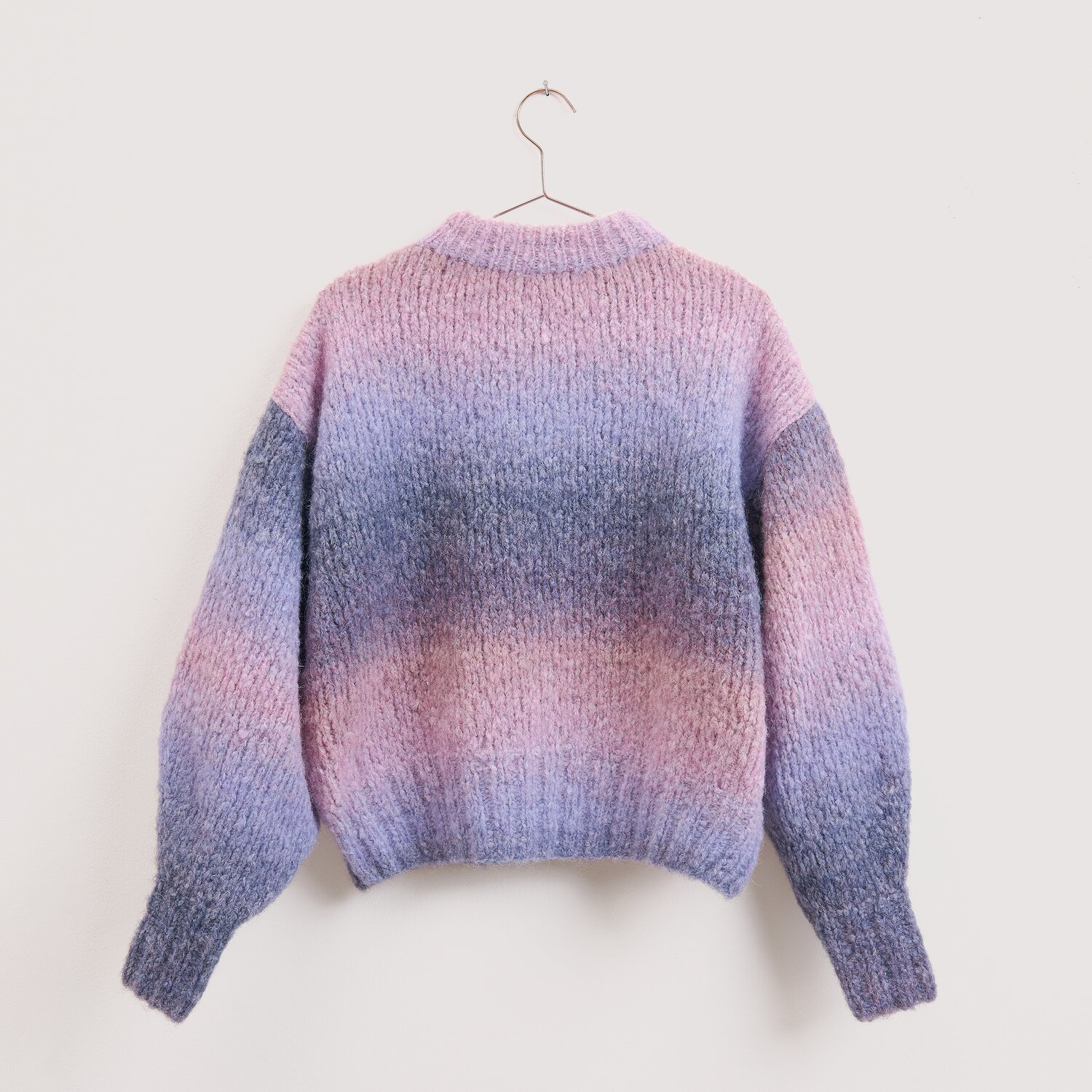 Die Neue Masche No. 16 Herbst, Strickpullover von Wolle Rödel mit weichem Farbverlauf, lockerer Passform und langen Ärmeln, hängend an schlichtem Bügel