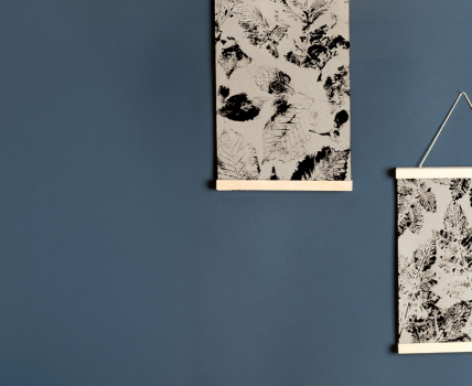 Selbst gestaltete Herbstbilder mit Blattmotiven an einer blauen Wand aufgehängt.