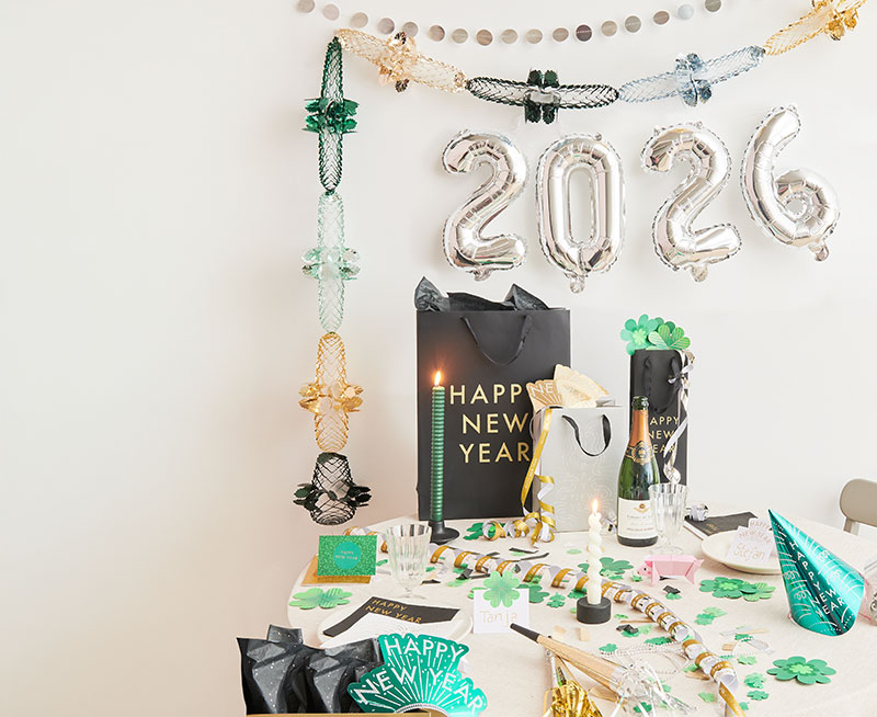 Tisch mit Silvester Partydeko, an der Wand hängt 2026 als Folienballon