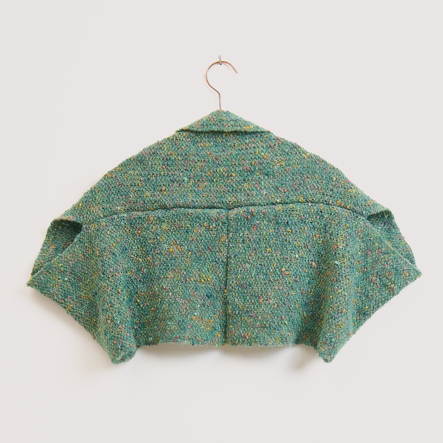 Die Neue Masche No. 16 Herbst gestricktes, kurz geschnittenes Schultertuch von Wolle Rödel auf Bügel, strukturierte Oberfläche mit dezentem Melange-Effekt