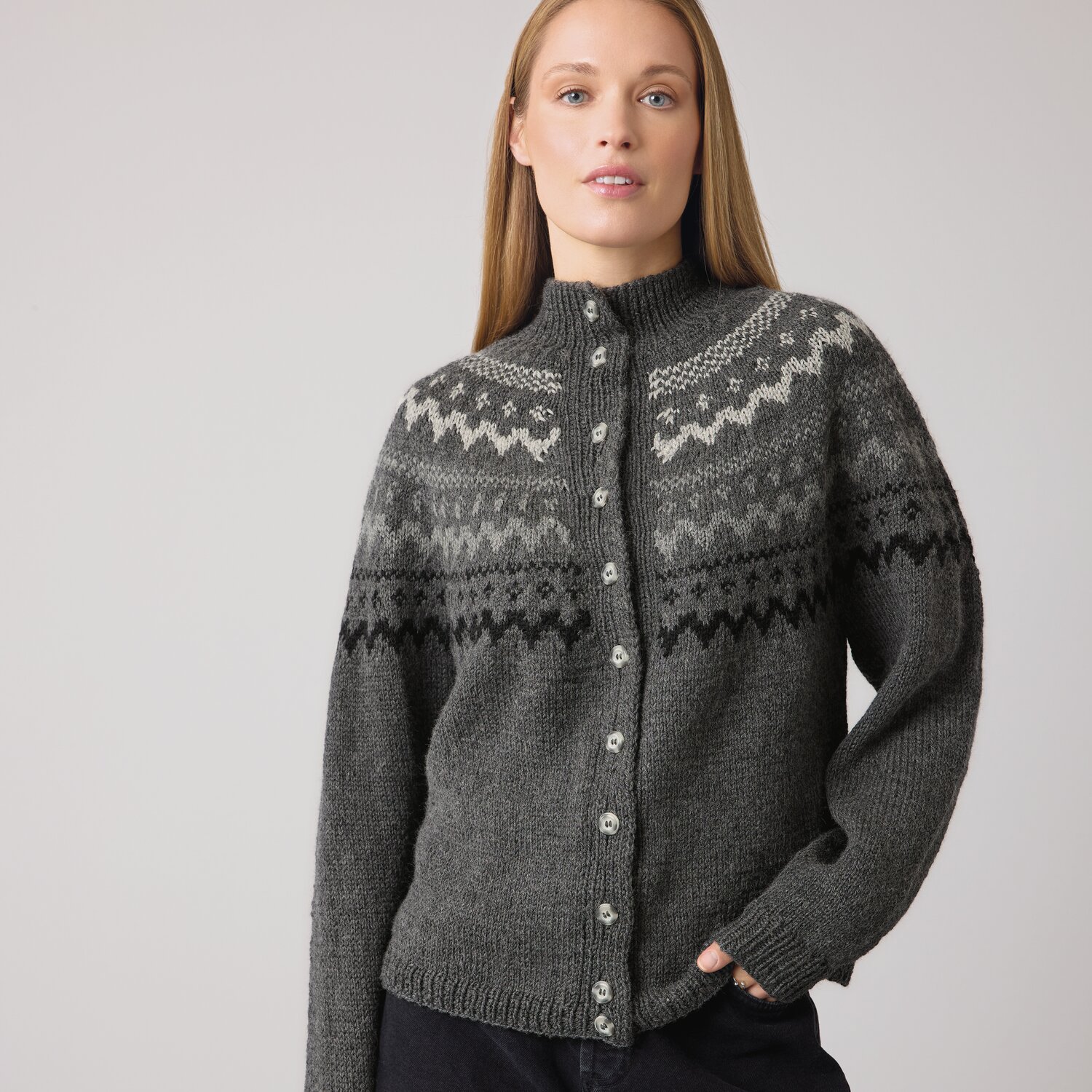 Strickset Jacke Modell 28 aus Die Neue Masche No. 14 von idee. Creativmarkt Strickset Jacke Modell 28 aus DNM 14, graue Strickjacke mit Knopfleiste und Muster, getragen von Frau.