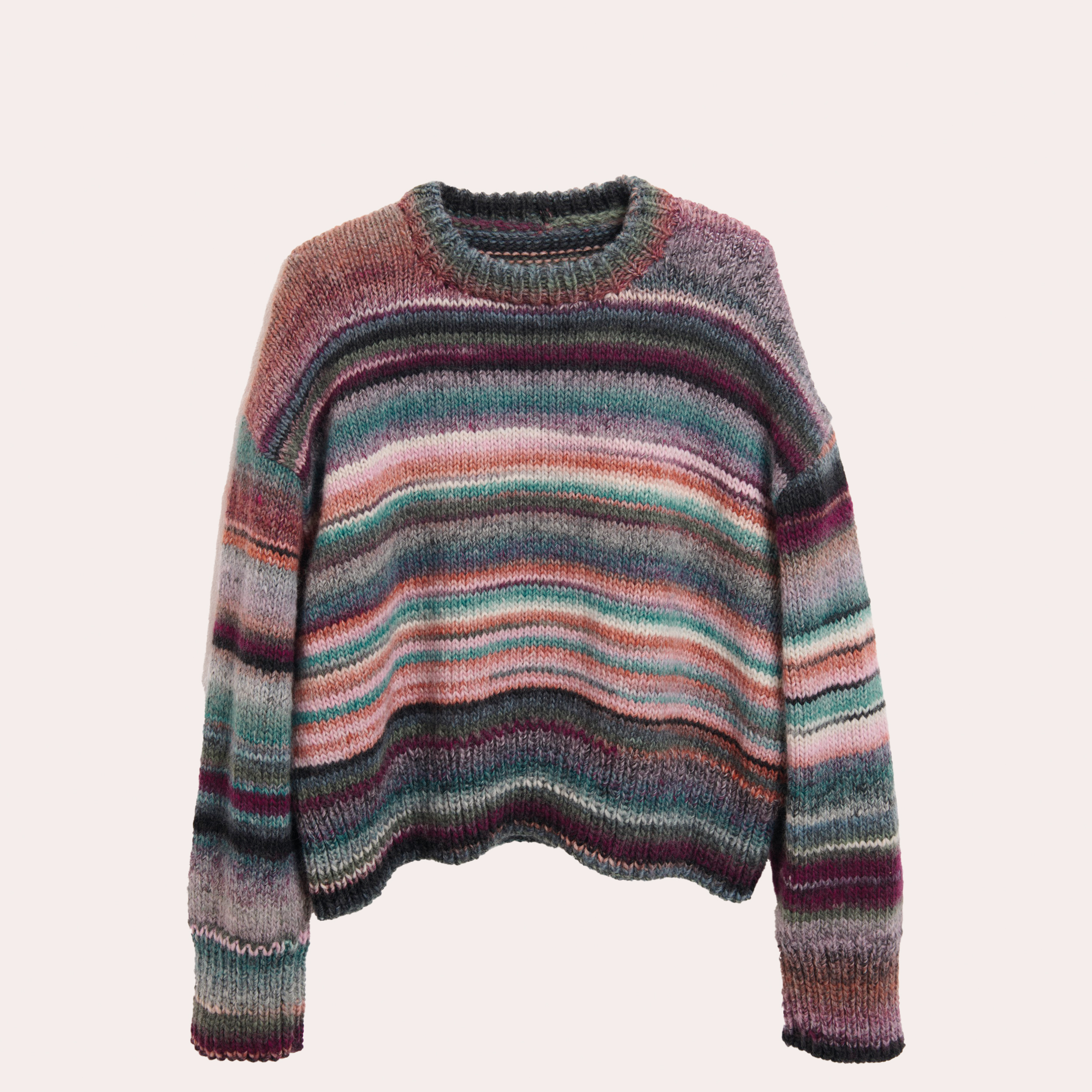 Damenstrickpullover mit Farbverlauf liegt auf beigefarbenem Untergrund