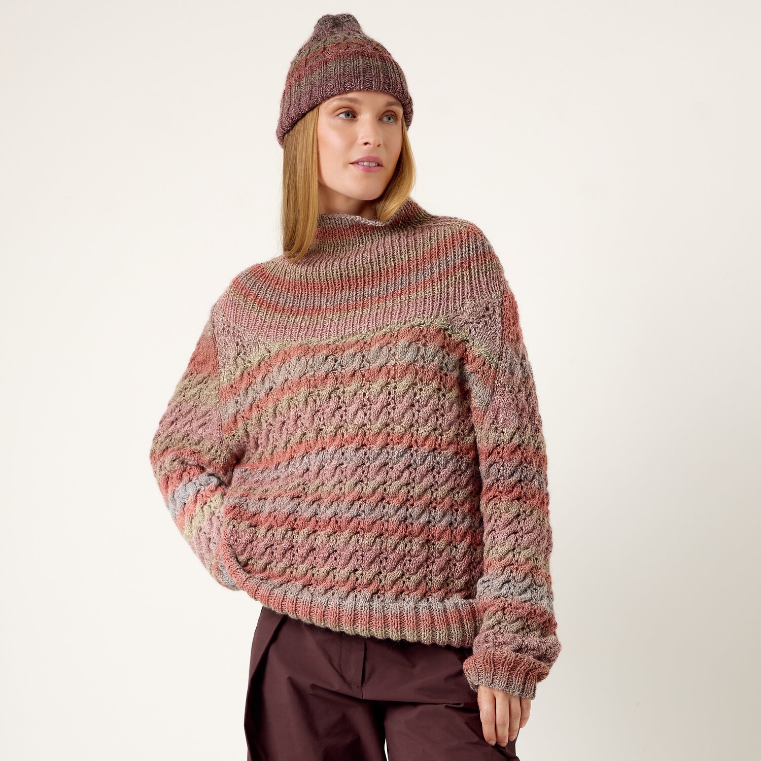 Strickset Pullover Modell 15 aus Die Neue Masche No. 13 von idee. Creativmarkt Strickset Pullover Modell 15: Frau trägt gestrickten Pullover in Erdtönen mit passender Mütze.