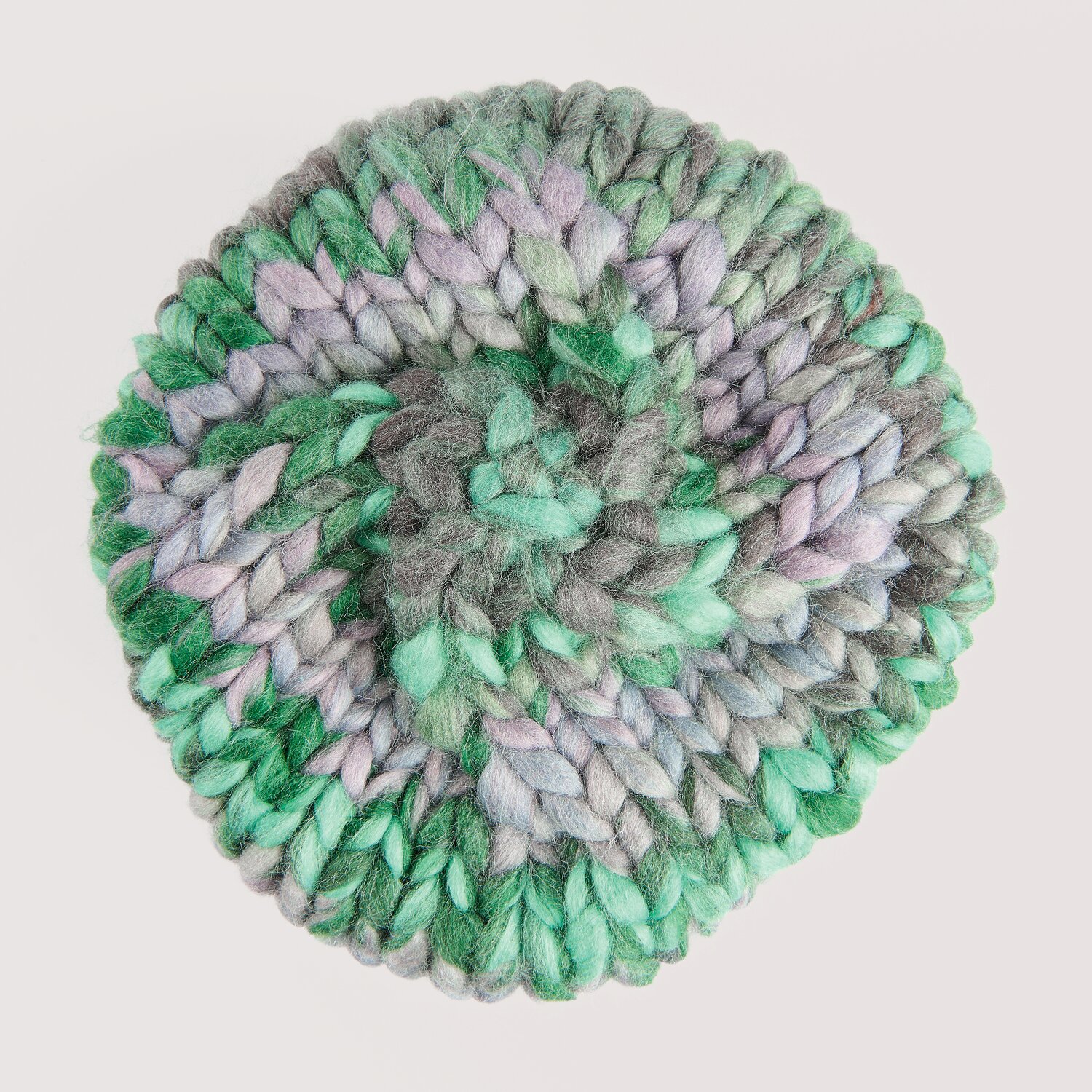 Die Neue Masche No. 16 Herbst, gestrickte Mütze von Wolle Rödel mit dicker, melierter Struktur in Grün- und Grautönen, von oben fotografiert.