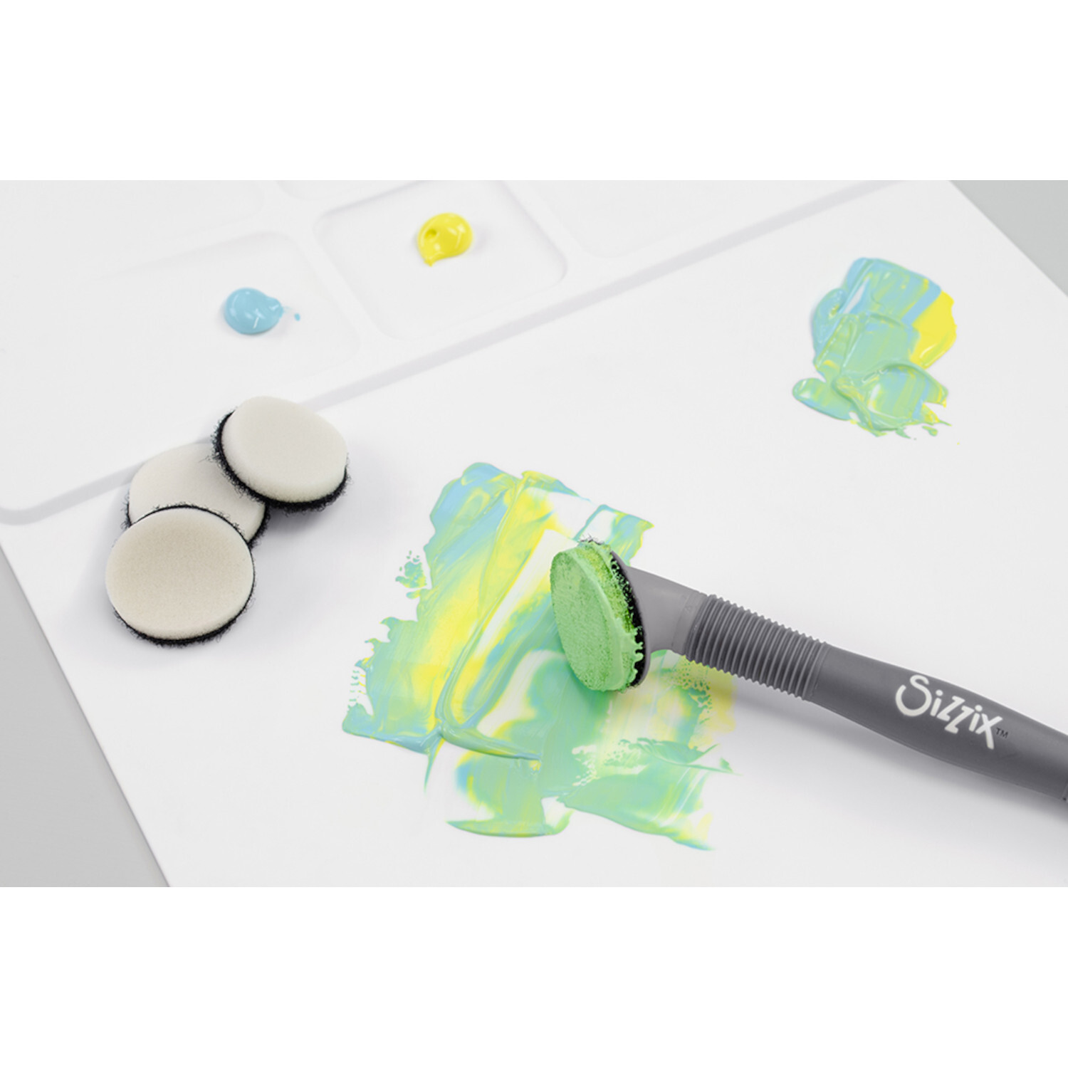 Studio Multi Tool Accessory Blending Tool Sponge Head von idee. Creativmarkt Studio Multi Tool Accessory Blending Tool Sponge Head von Sizzix auf weißem Papier mit bunten Farbmischungen.