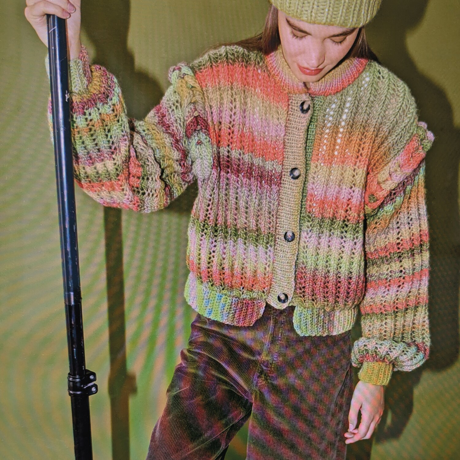 Strick-/Häkelset Jacke Modell 25 aus Made by Me No. 21 von Rico Design Strick-/Häkelset Jacke Modell 25 aus Made by Me No. 21, bunte Strickjacke mit Knöpfen, getragen von Frau mit Mütze.