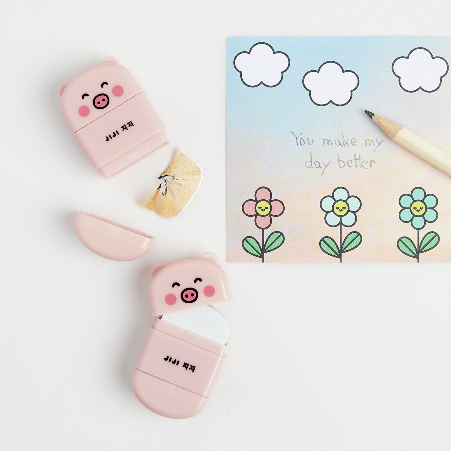 Paper Poetry Radiergummi mit Anspitzer Schwein in Rosa neben einer bunten Karte mit Blumenmotiv.