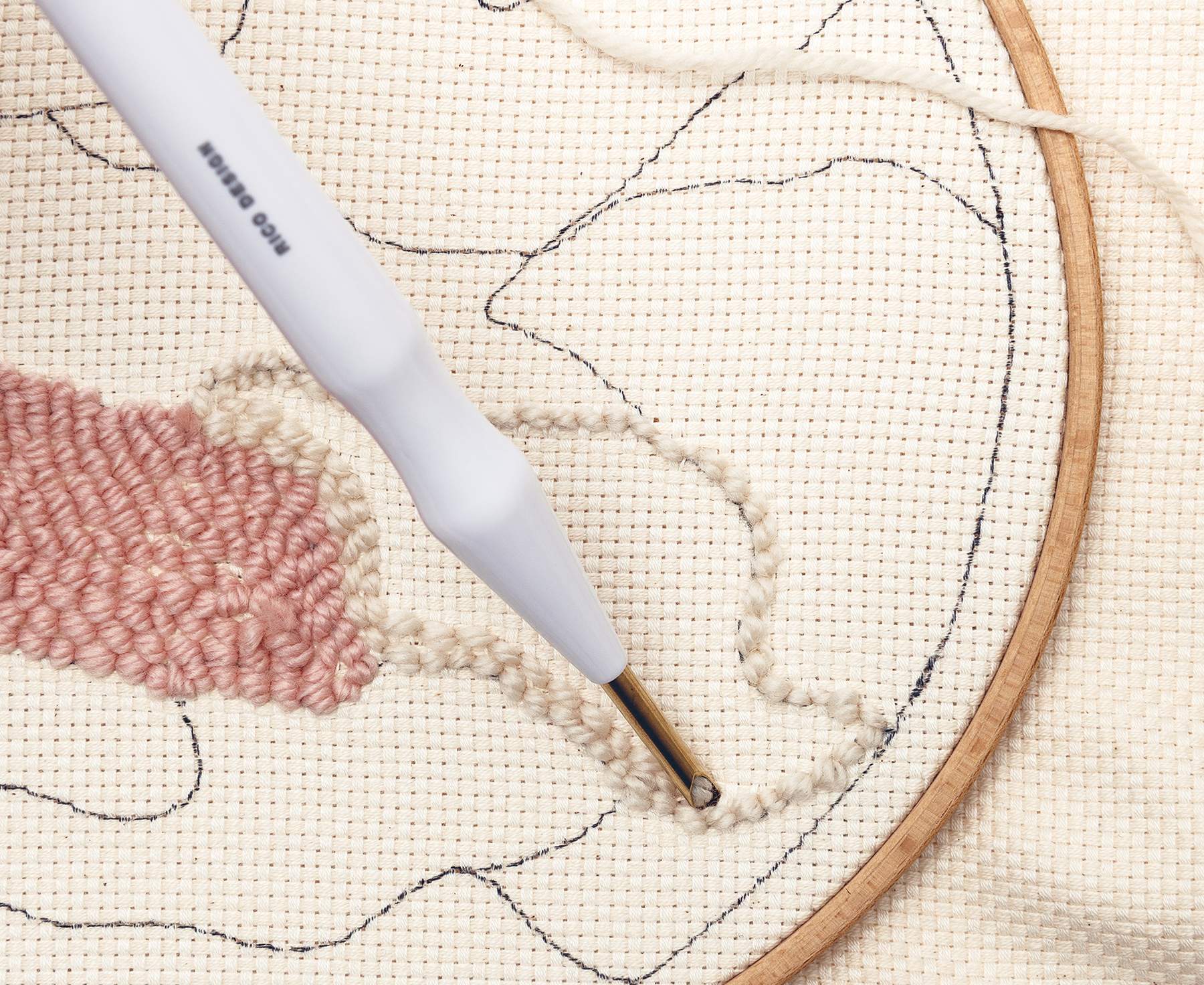 Punch Needle stickt Wolle in einen Stoff