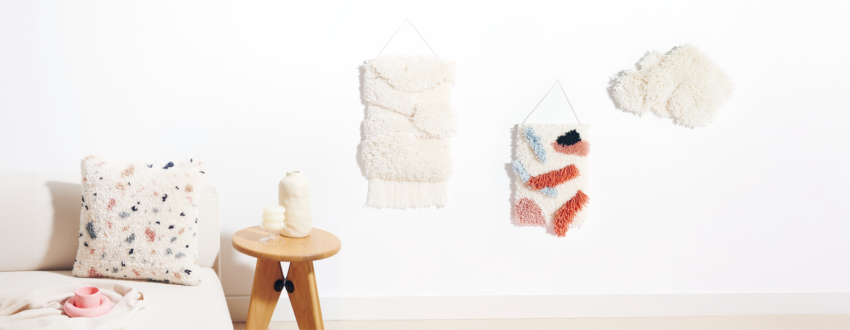 Geknüpfte Wandbehänge und Kissen in wohnlicher Kulisse