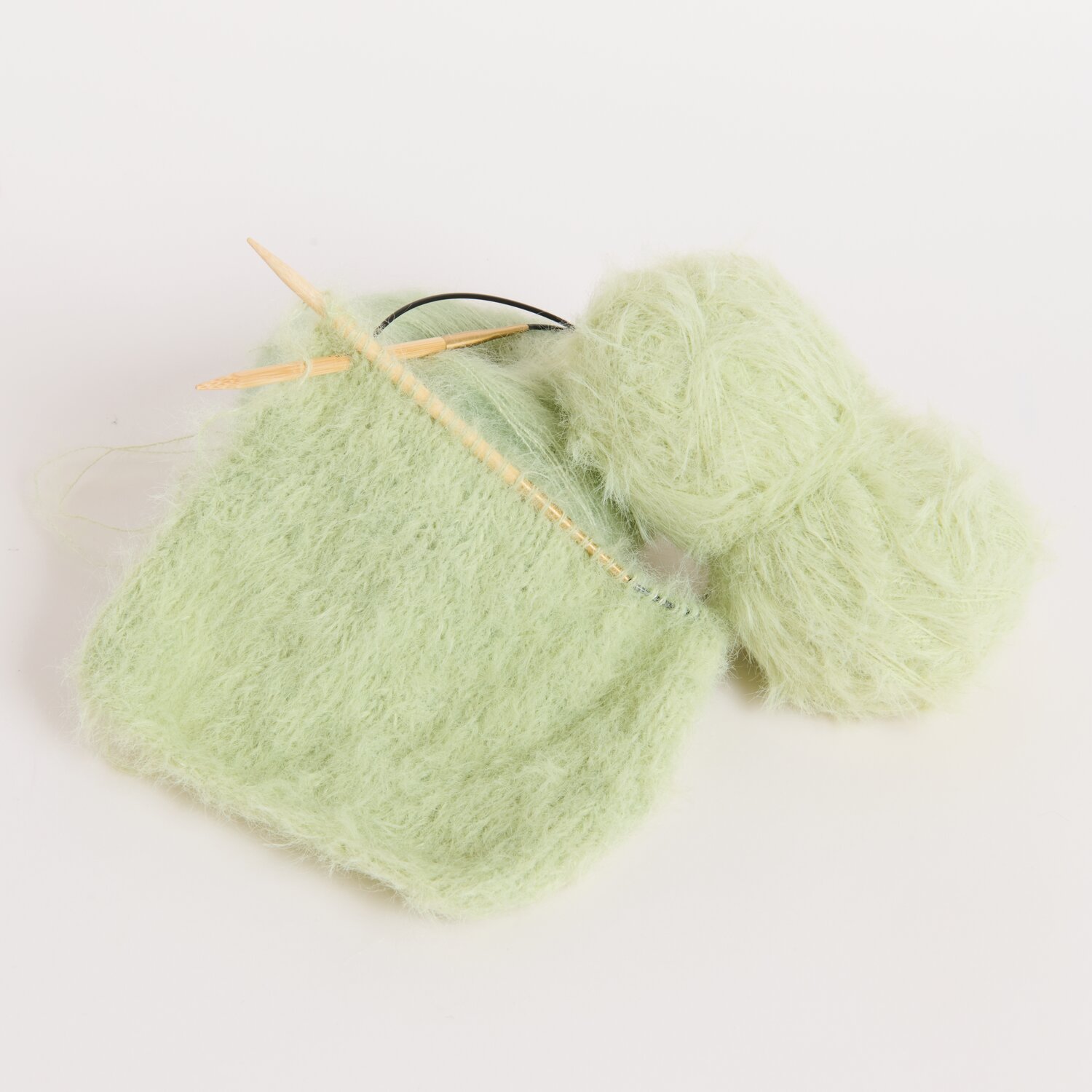 Made by Me No. 22 Frühjahr-Sommer: Strickprojekt mit grünem Mohairgarn und Stricknadeln.