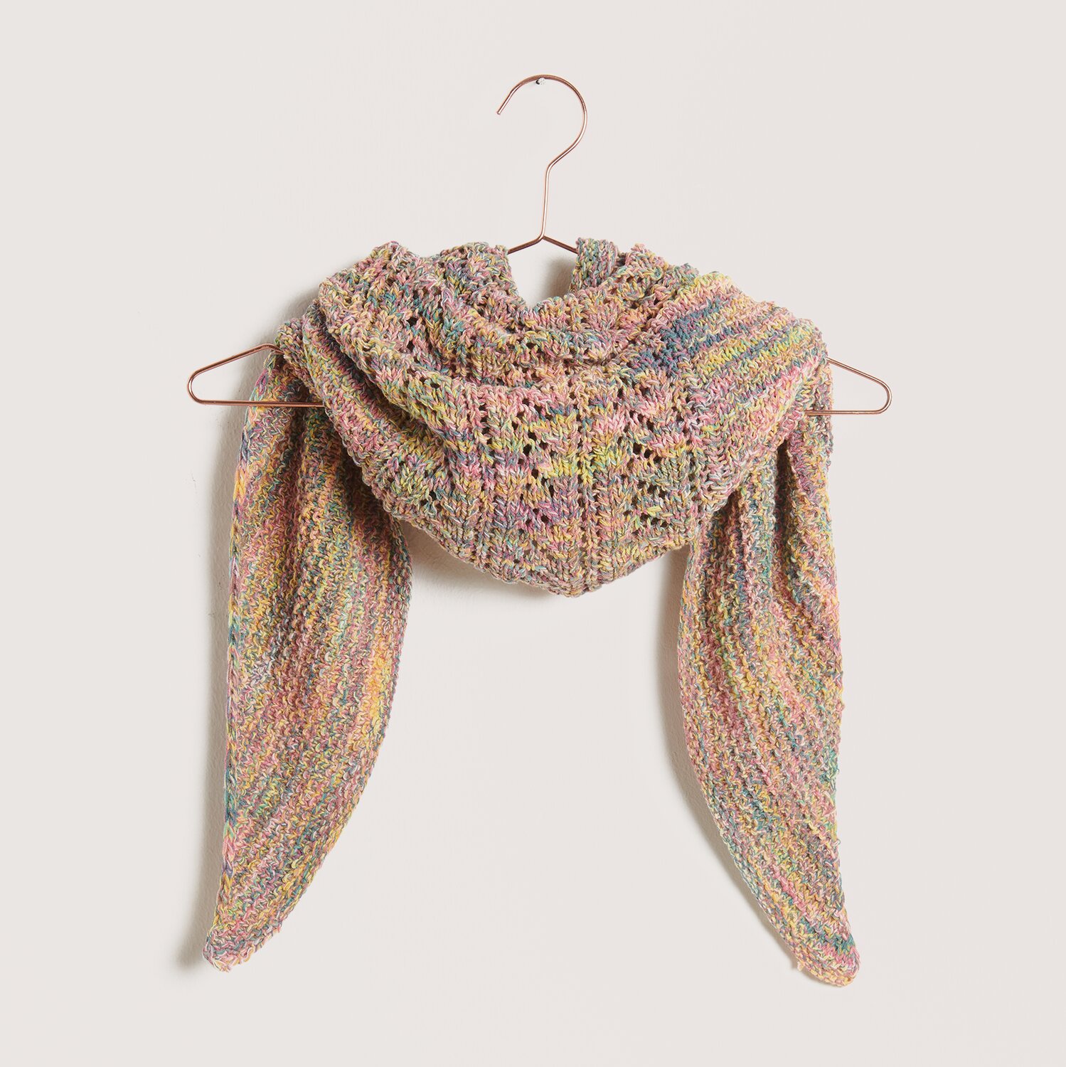 Strickset Dreieckstuch Modell 26, buntes Muster, aufgehängt an einem Kleiderbügel. Ideal für Frühjahr-Sommer.