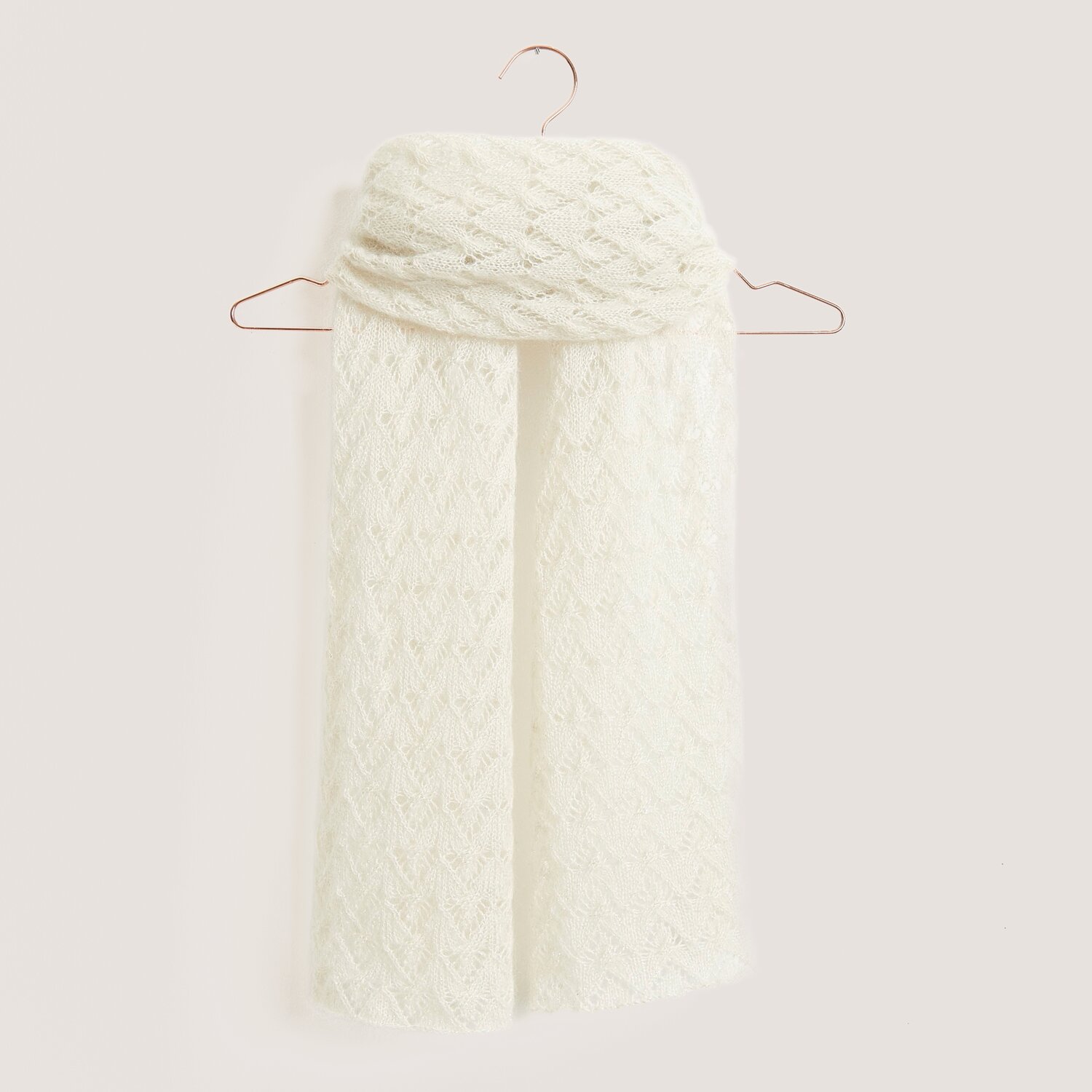 Strickset Tuch Modell 05 aus cremefarbenem Mohair-Seidengarn, elegant drapiert auf einem Kleiderbügel.