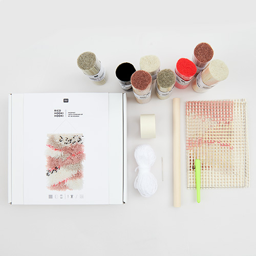 Ein Knüpfset mit Knüpfgarn, -haken, -stramin und Tape. Flatlay von Produkten.